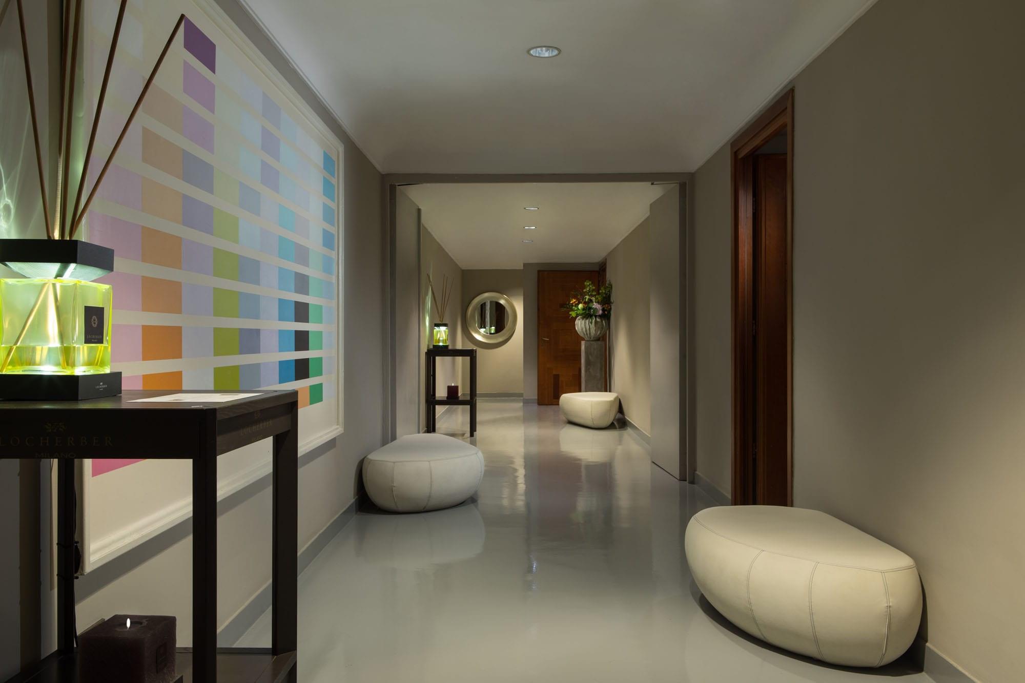 Hotel de Russie: modern spa corridor with soft lighting, rounded poufs, and color palette samples on wall