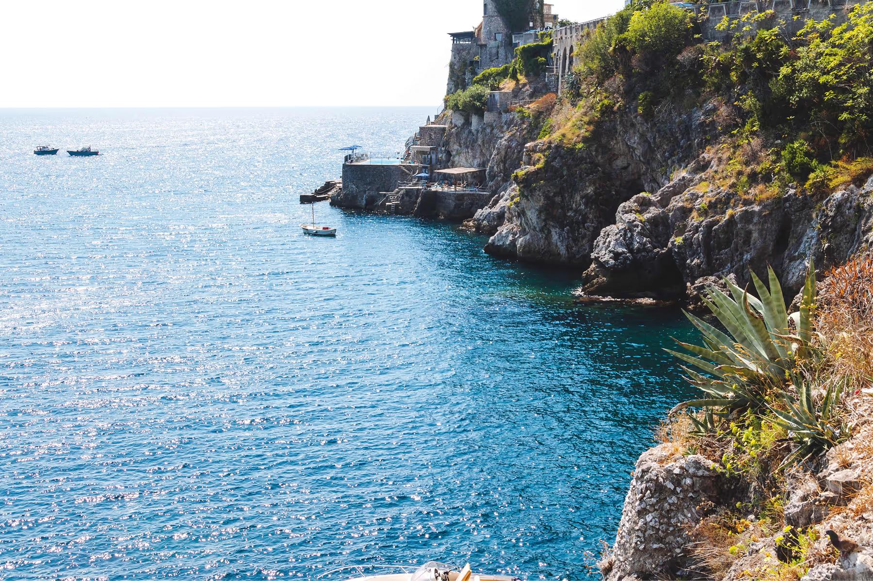 Caruso: rocky coastal outcrop with terraced white buildings cascading down cliff to turquoise water