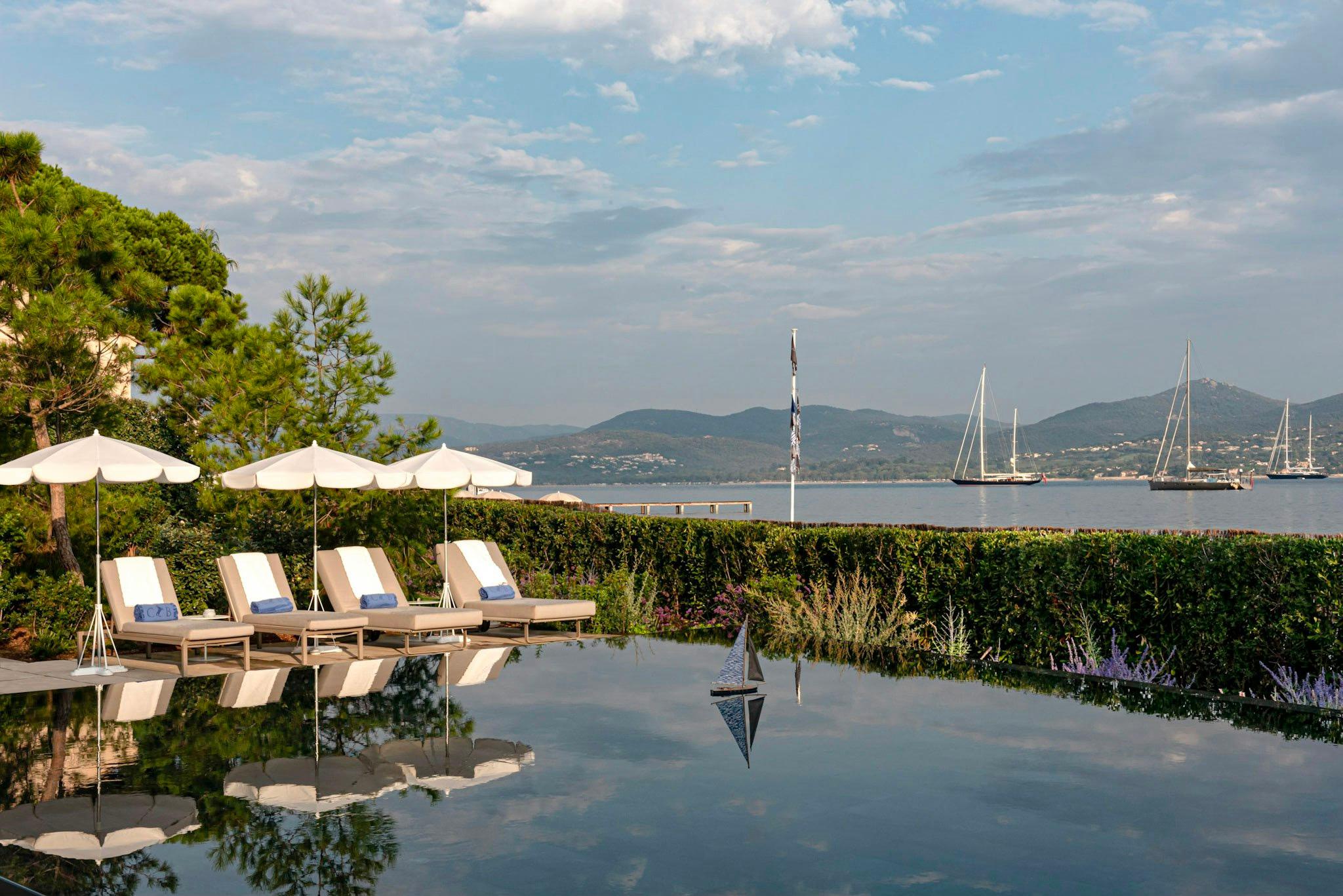 Cheval Blanc St-Tropez: waterfront pool with sunbeds overlooking moored boats