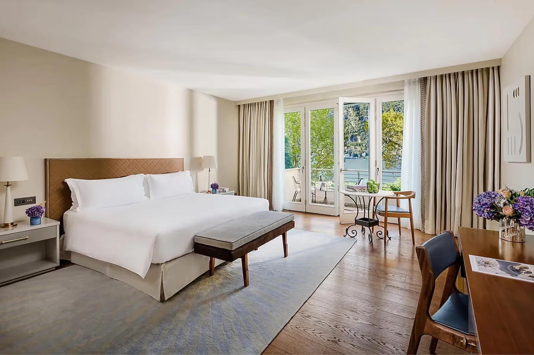 Mandarin Oriental, Lake Como: bedroom with white linens and wood accents opening to views of mountains and water