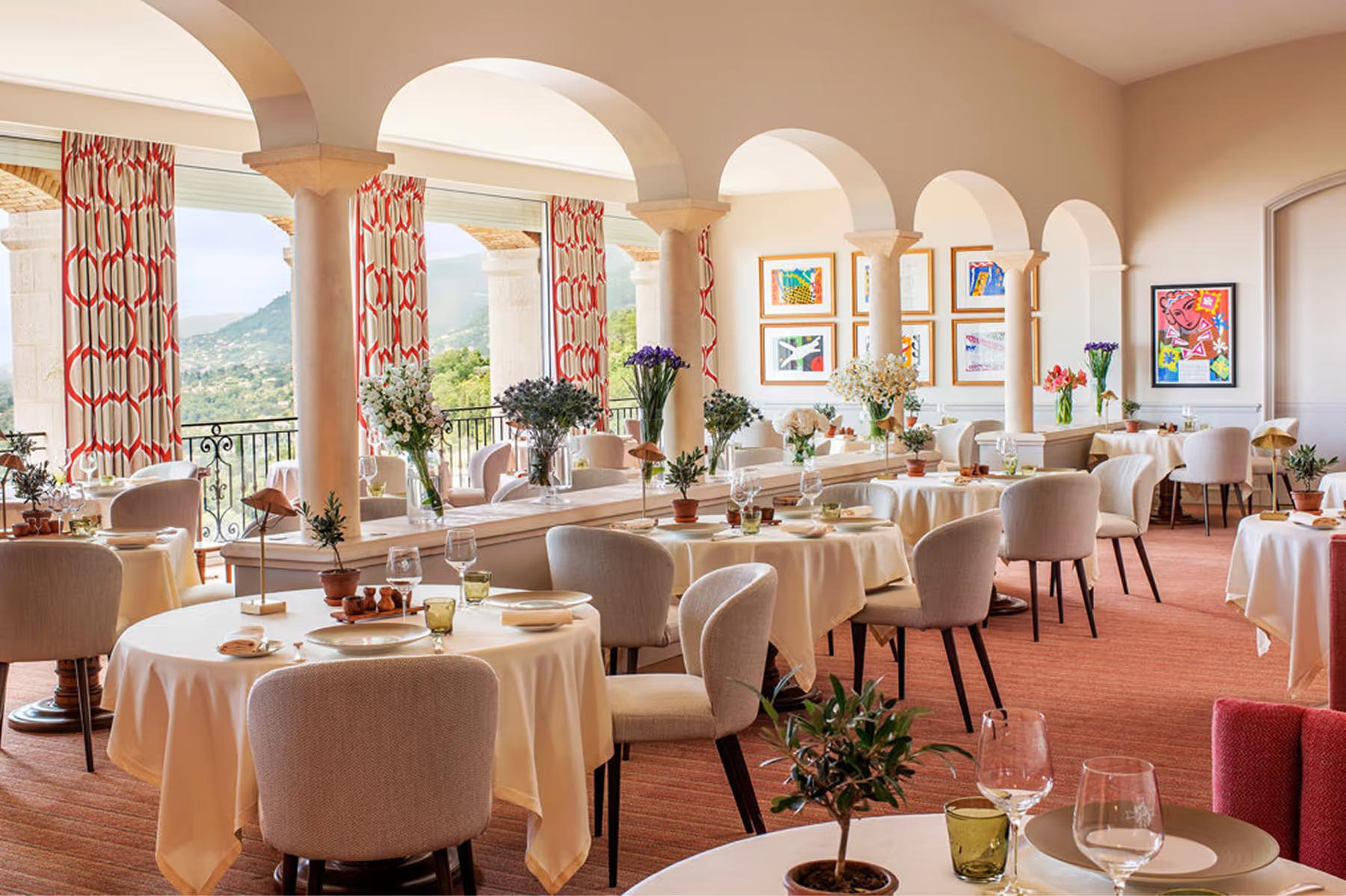 Château Saint Martin & Spa: formal dining room with arched windows and round tables in neutral tones