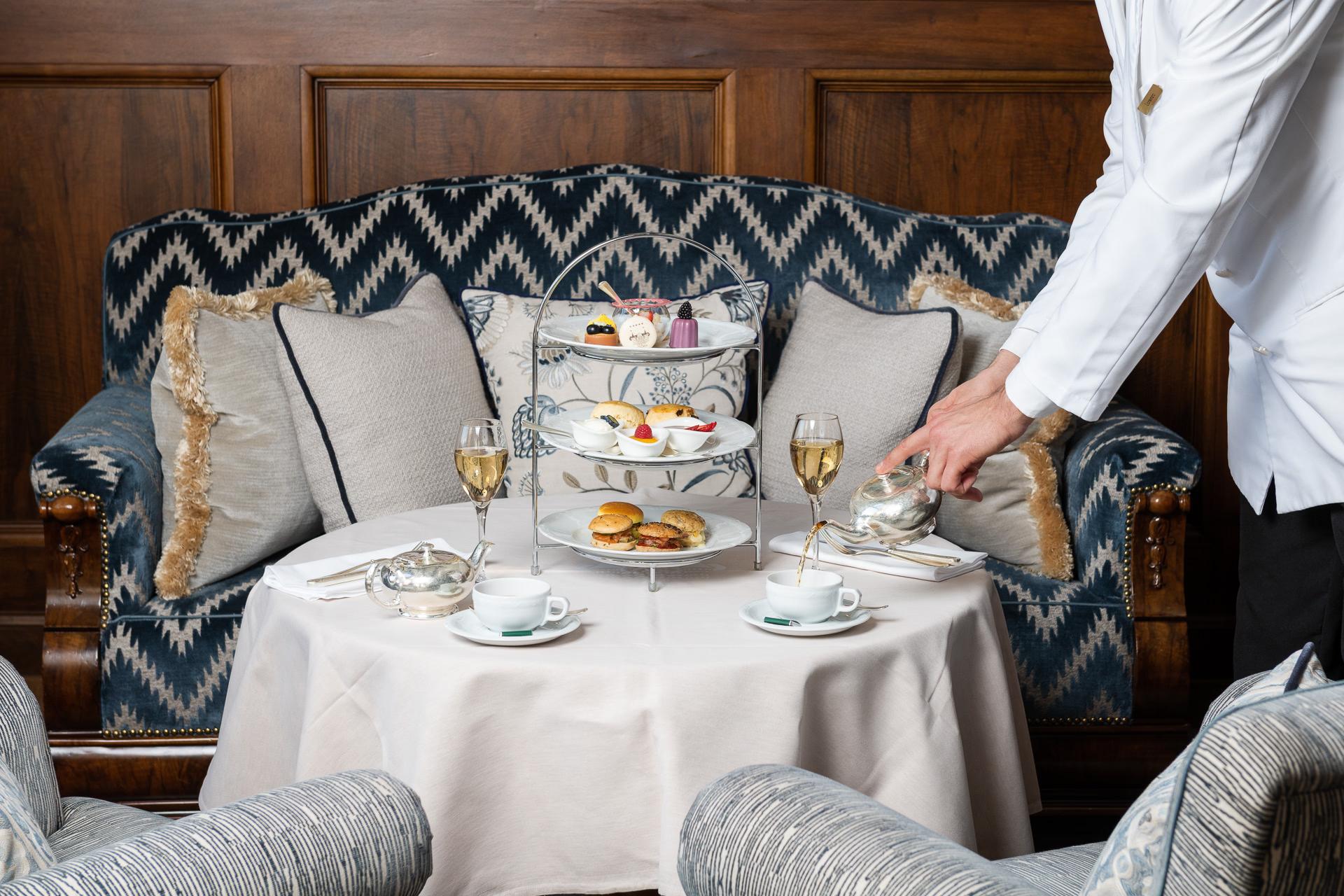 Suvretta House: an intimate dining moment with tiered afternoon tea service on patterned banquette seating