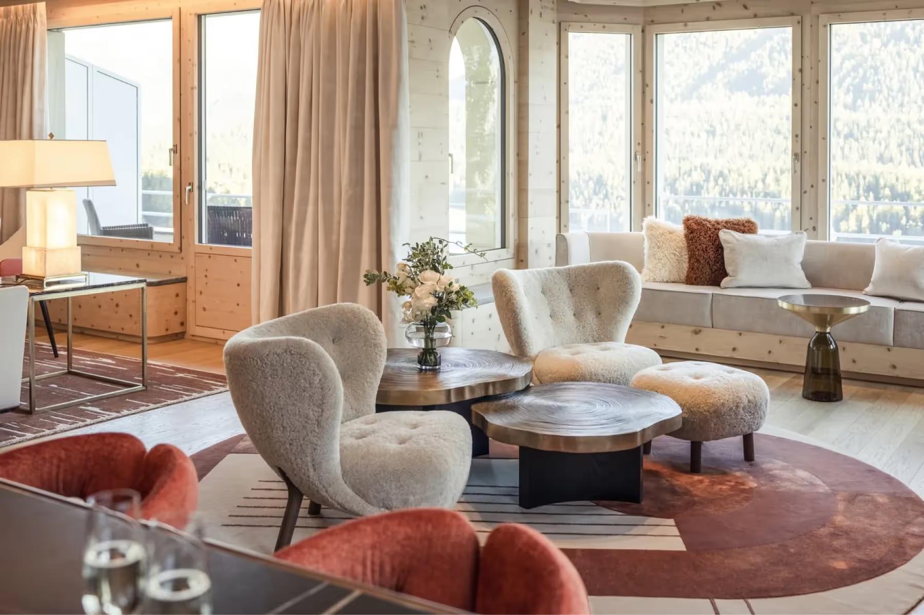 Kulm Hotel St. Moritz: an interior suite with large windows framing Alpine peaks and morning light