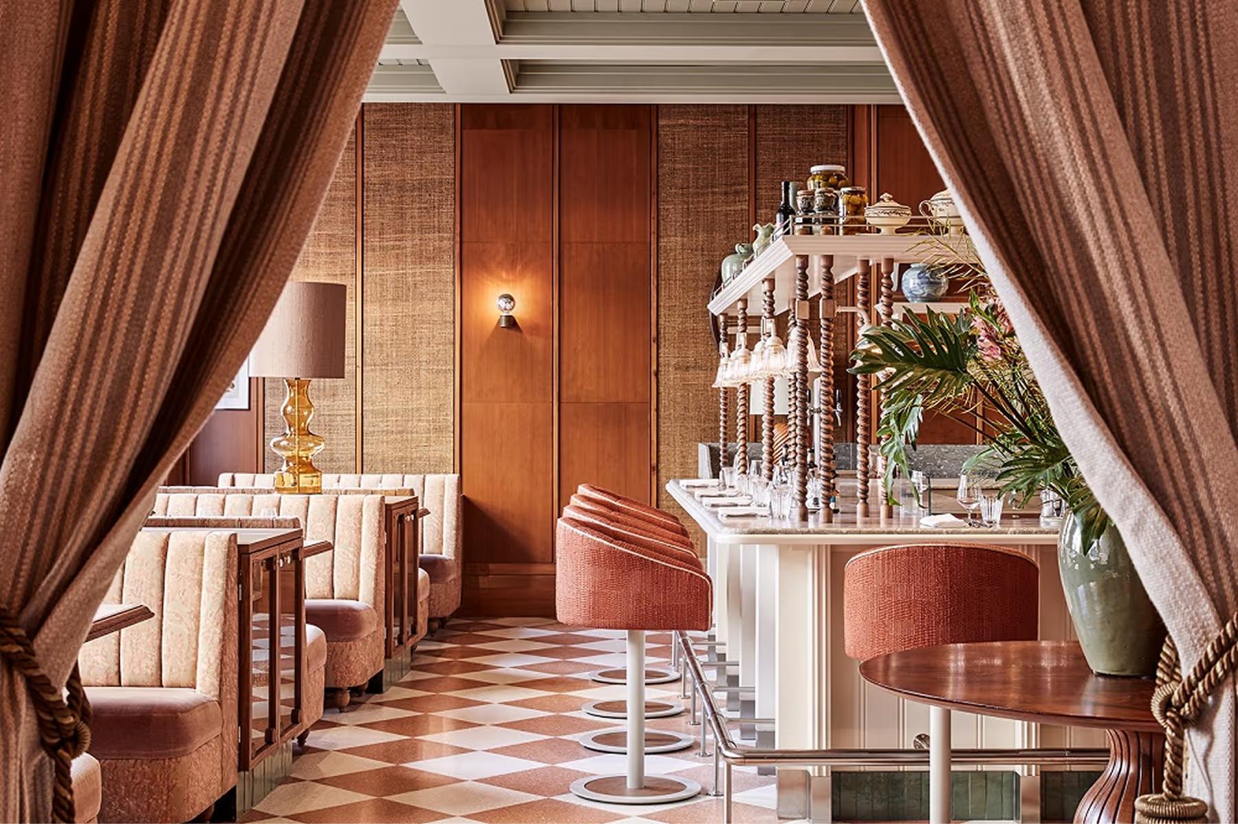 De L’Europe Amsterdam: hallway with terracotta tones, arched passages, and cream colored furnishings