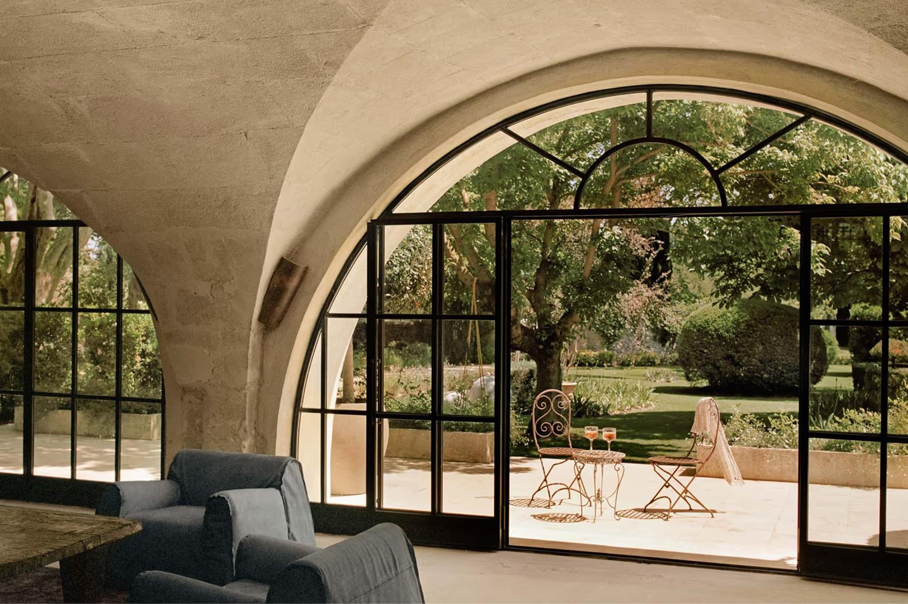 Le Mas de Chabran: arched portico with black iron framing opens to manicured terrace and distant landscape