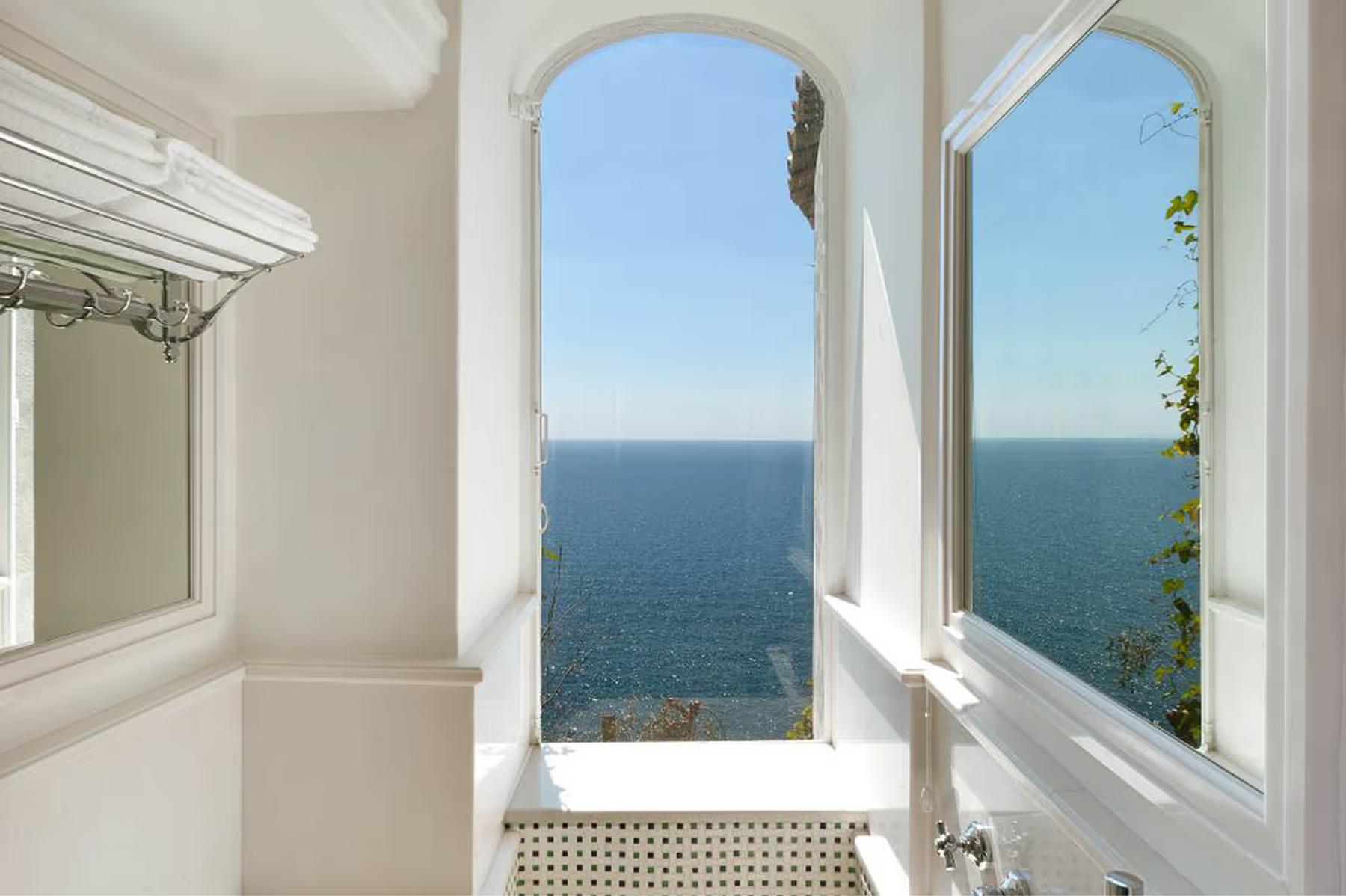 Il San Pietro di Positano: white arched window frames showing Mediterranean sea and sky from bedroom perspective