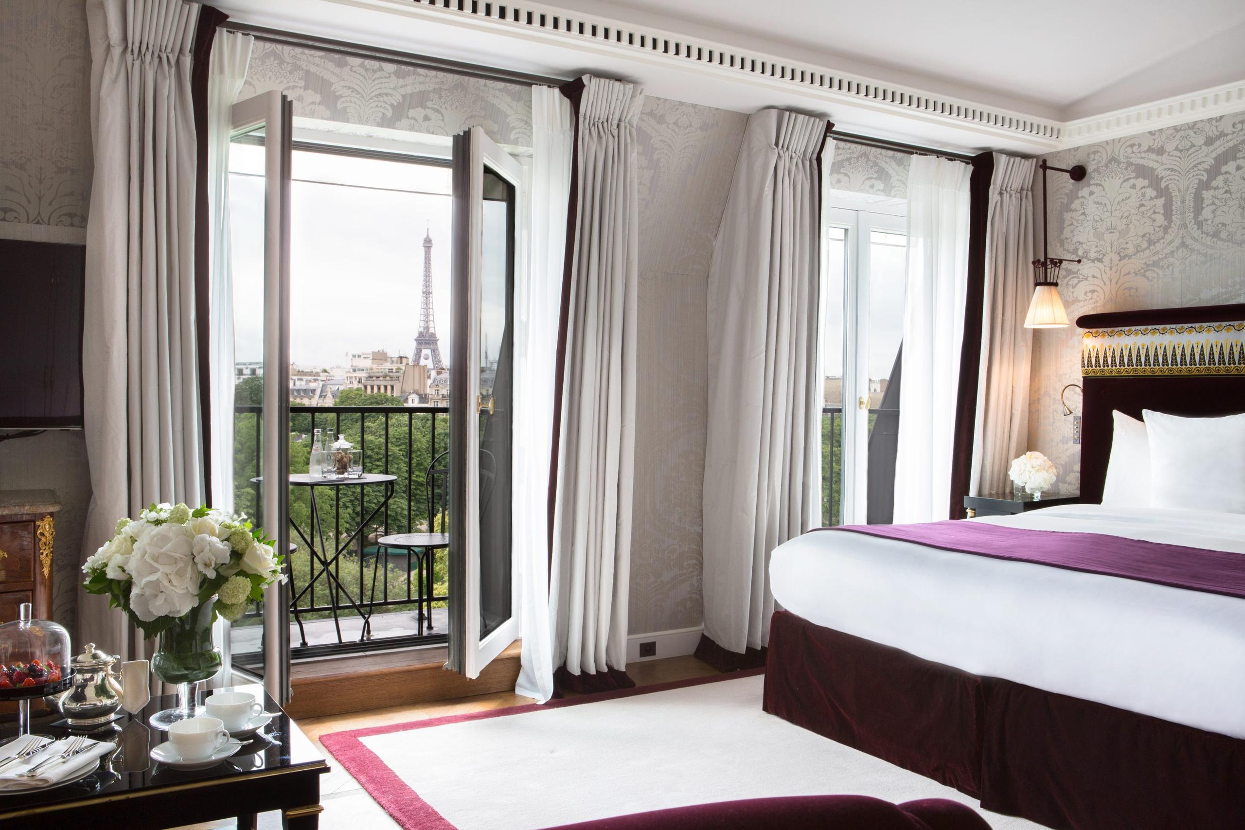 La Réserve Paris: a bedroom with floor-to-ceiling windows overlooking Parisian rooftops