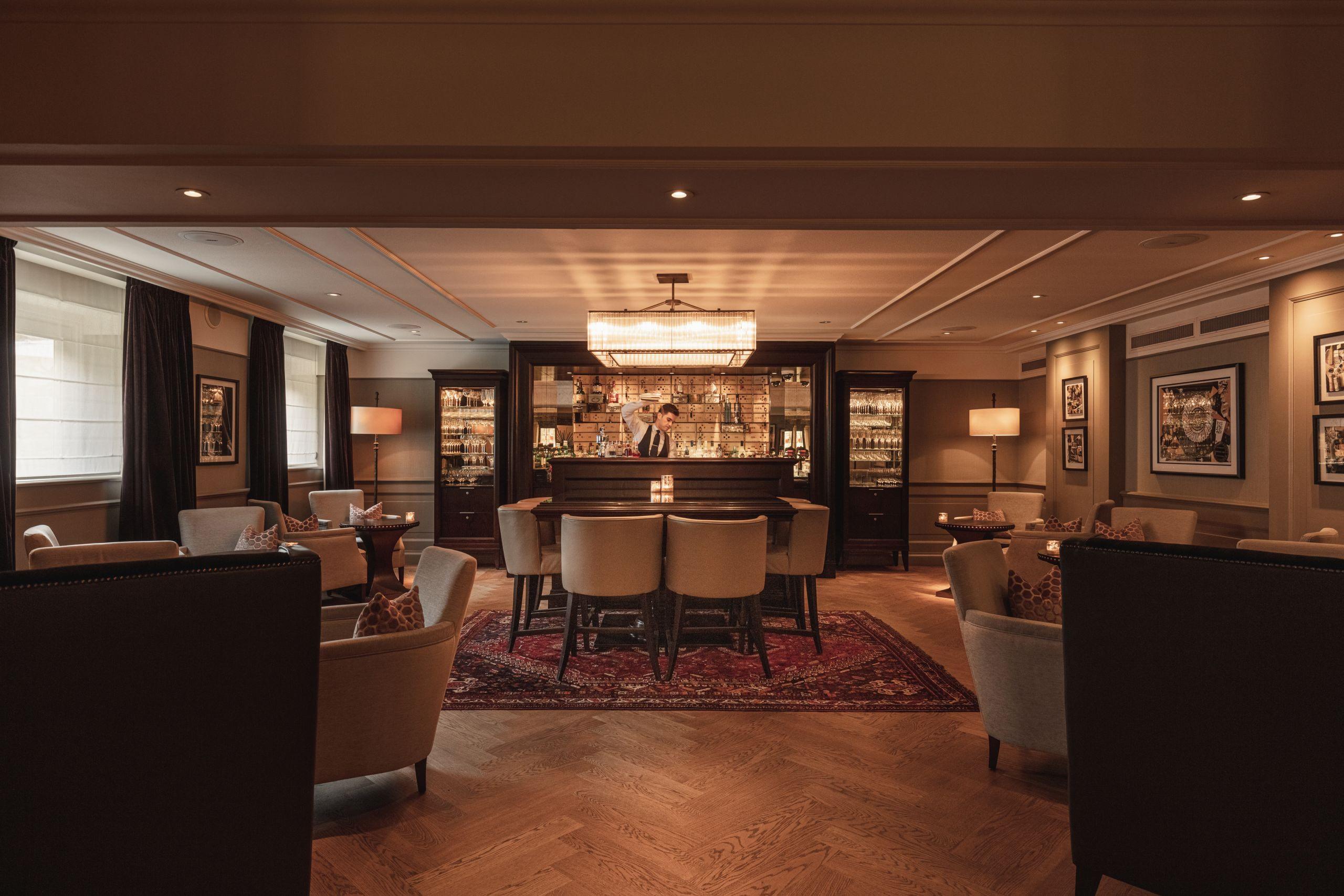 A lobby with dark wood finishes, illuminated display cabinets, and a warm-toned orientation counter