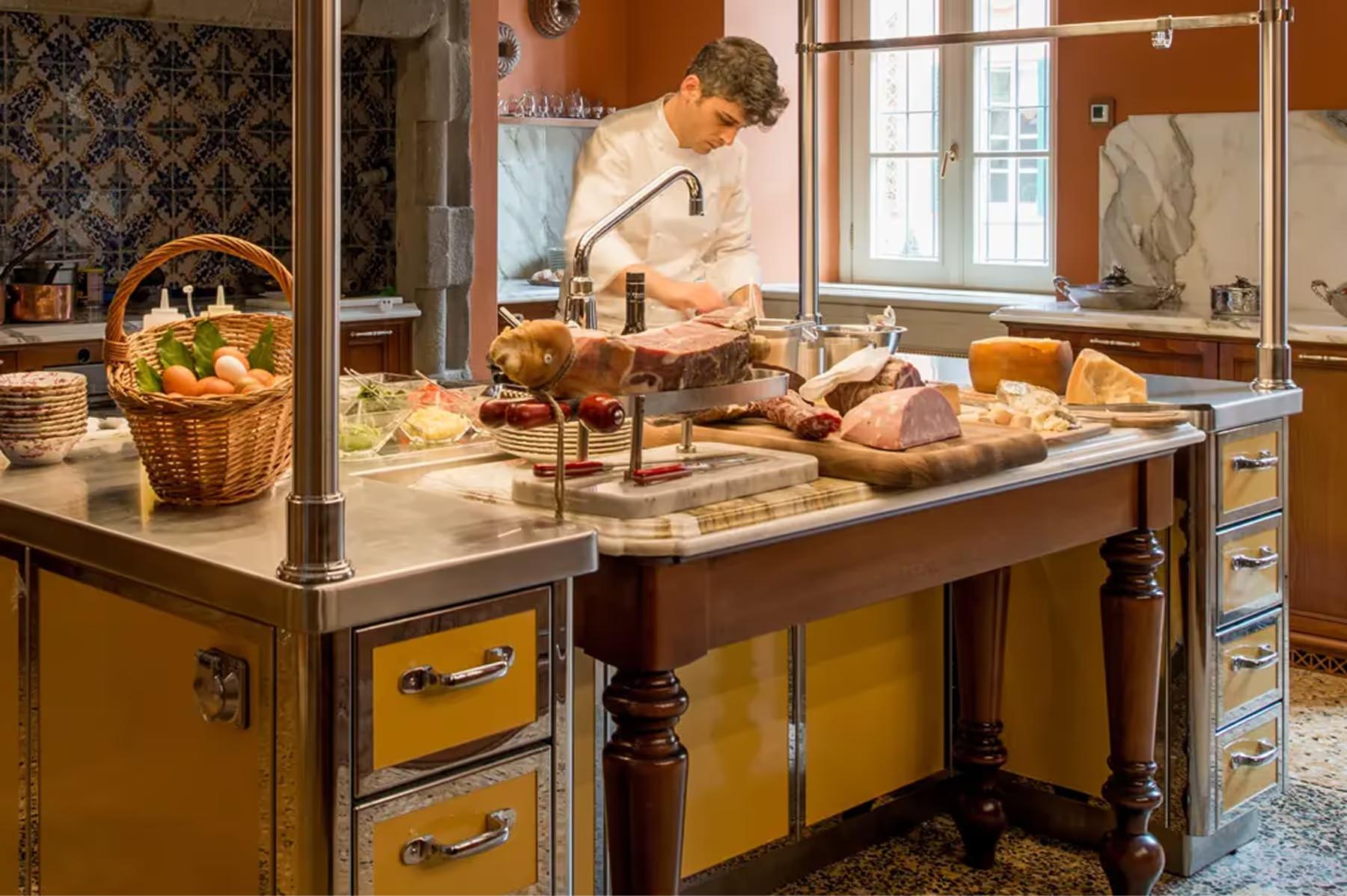 Passalacqua: a chef at work in a cream-colored kitchen with marble countertops and copper cookware