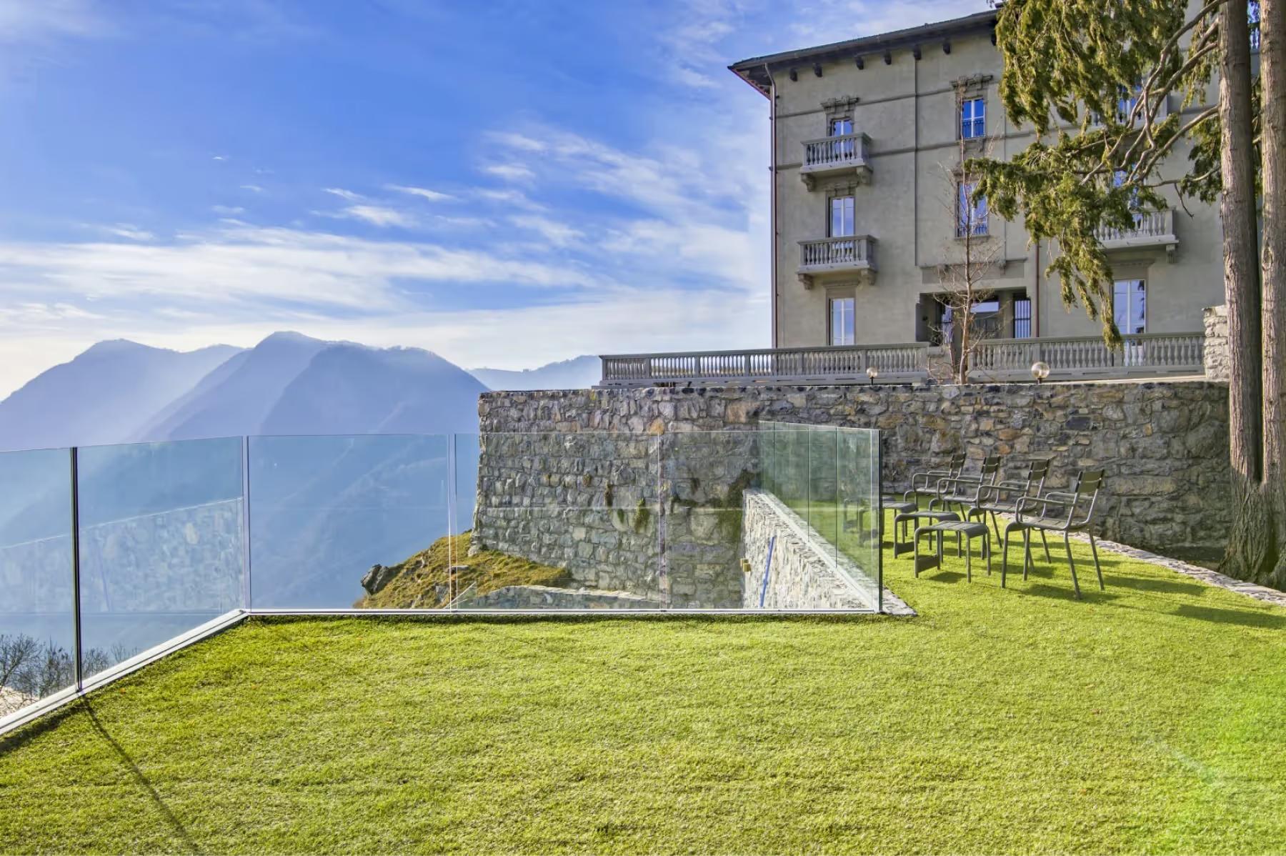 Villa Patrizia: the villa grounds with manicured lawn overlooking the lake and surrounding peaks