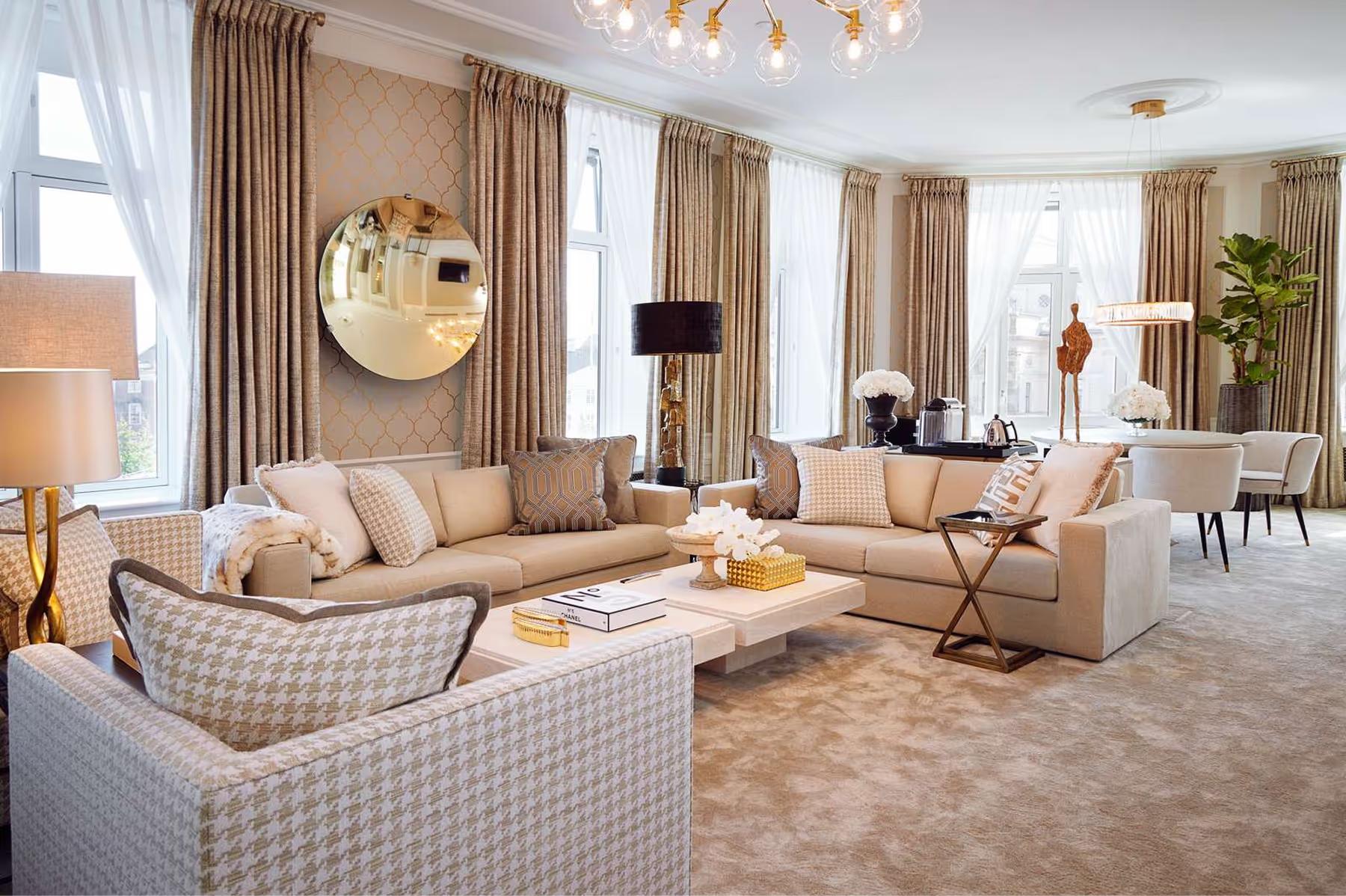 Hotel d’Angleterre: spacious suite with patterned sofas, round mirror, and tall windows