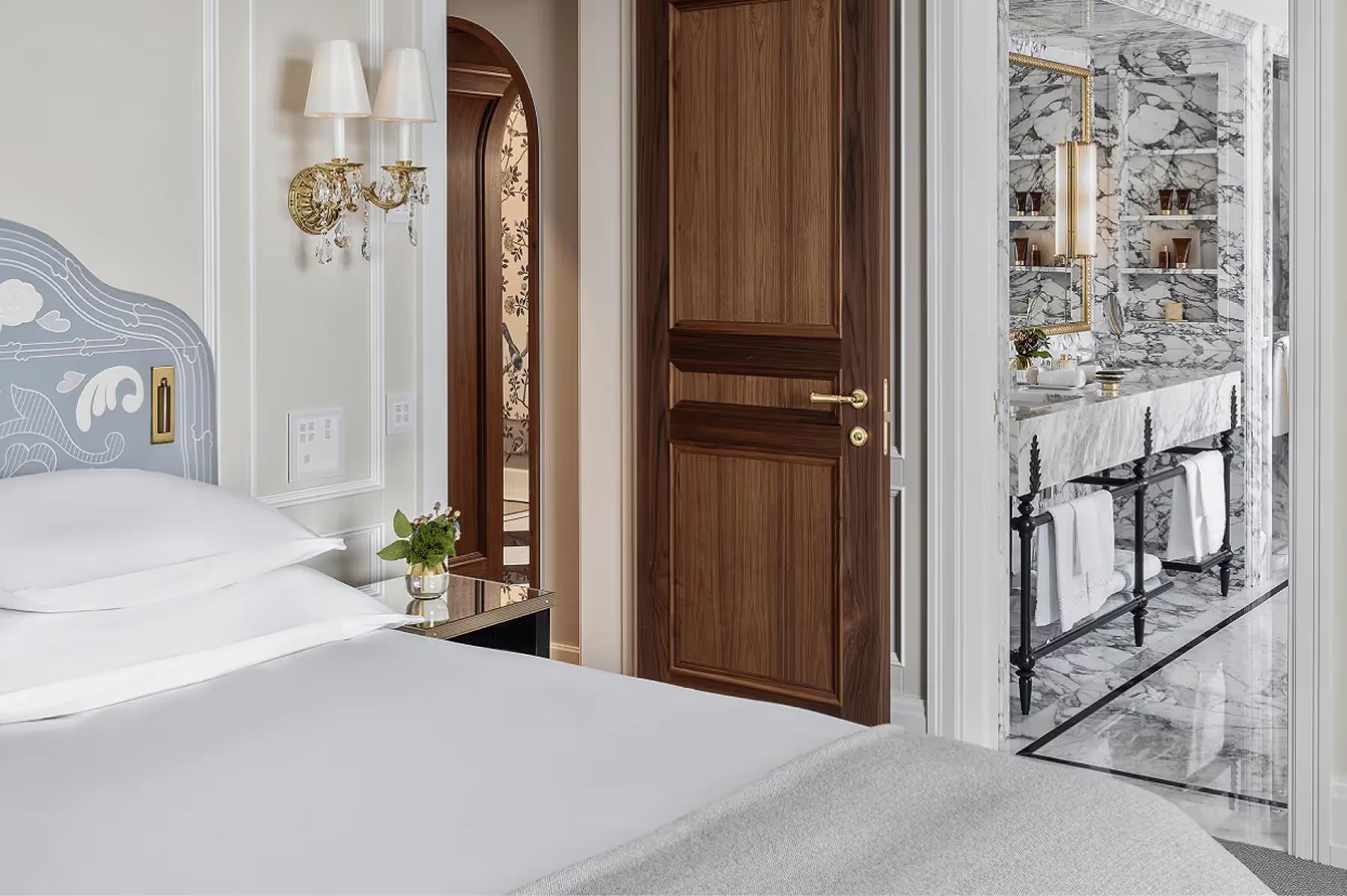 Badrutt’s Palace Hotel: hallway with white walls, wooden doors, and light stone flooring