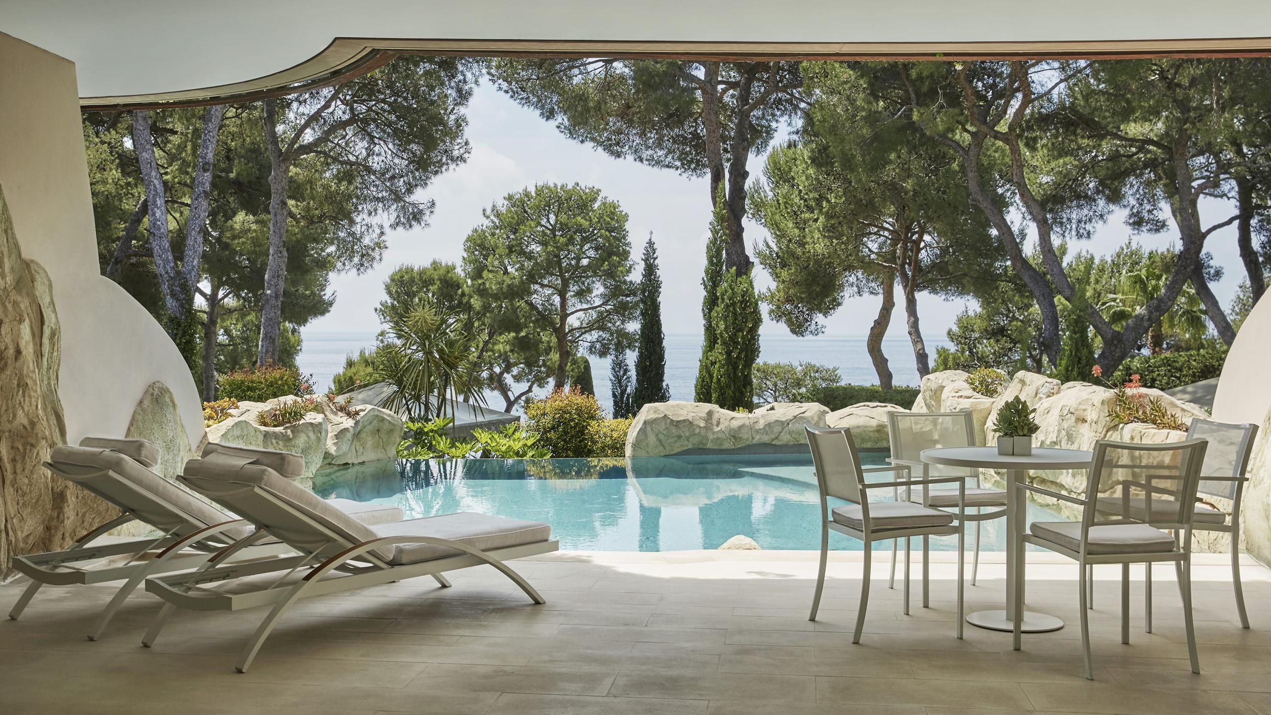 Shaded poolside lounge with Mediterranean plantings and sea horizon