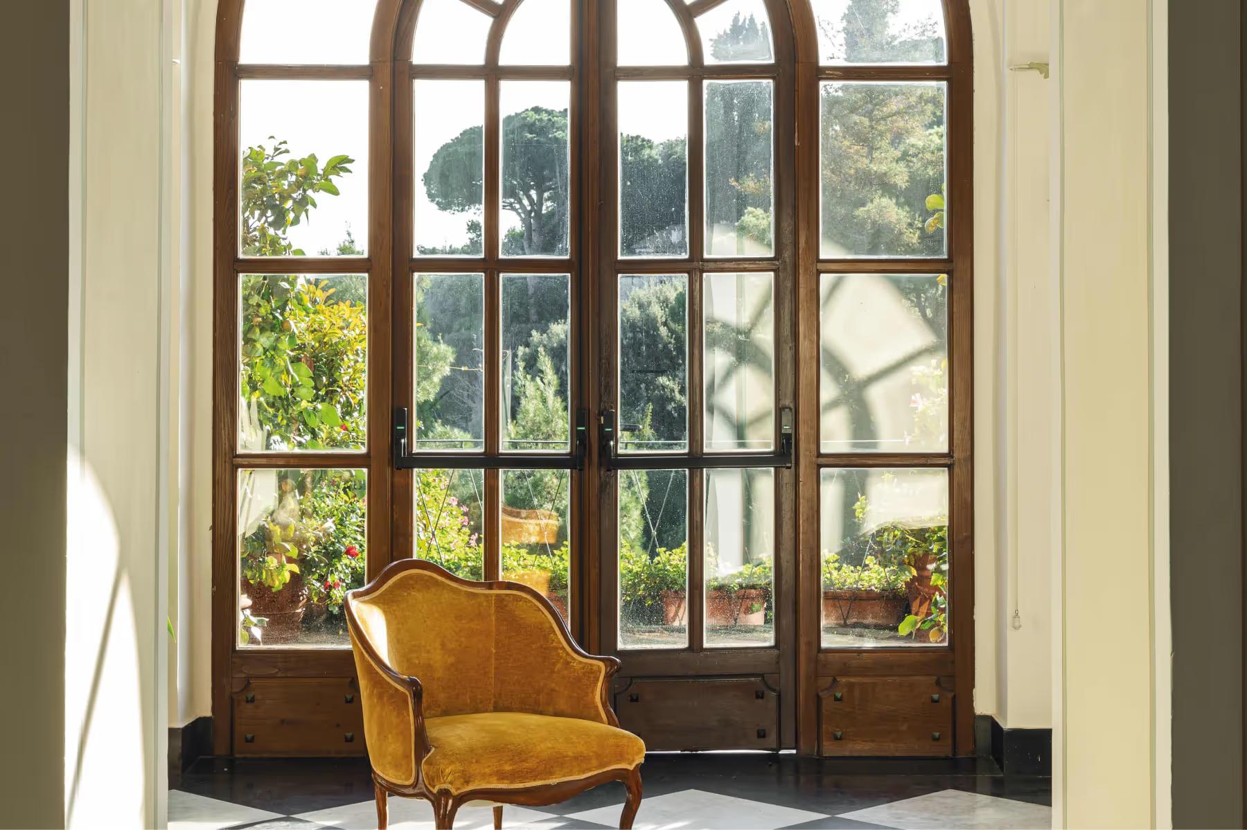 Splendido: large wood-framed glass doors with transoms opening to lush green views
