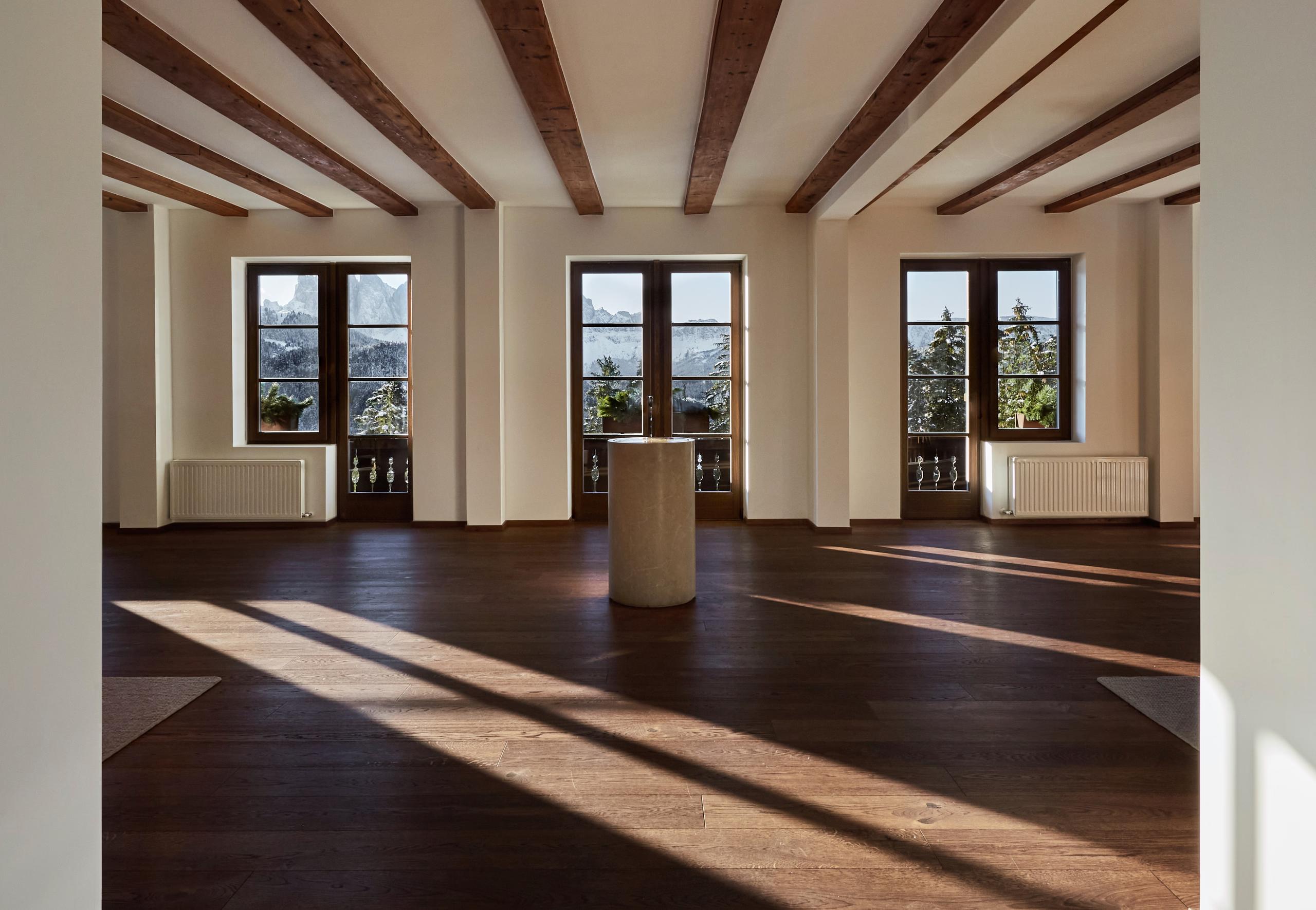Forestis: an interior corridor with light wood and concrete materials connecting different areas of the hotel