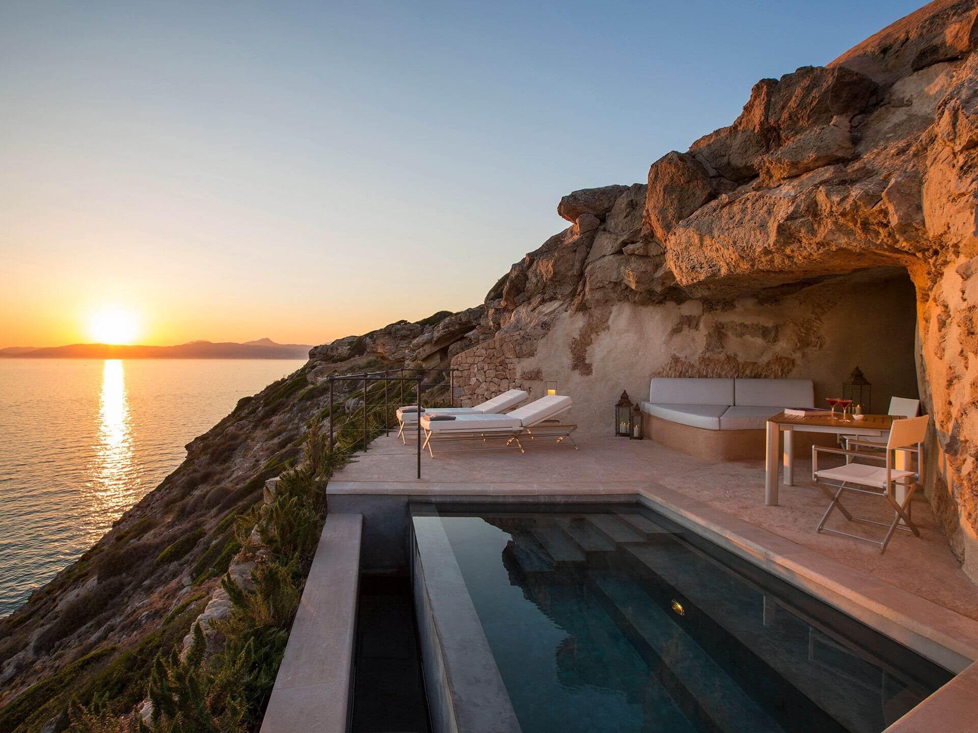 A wooden pergola frames a clear seascape, with dappled sunlight striping the view