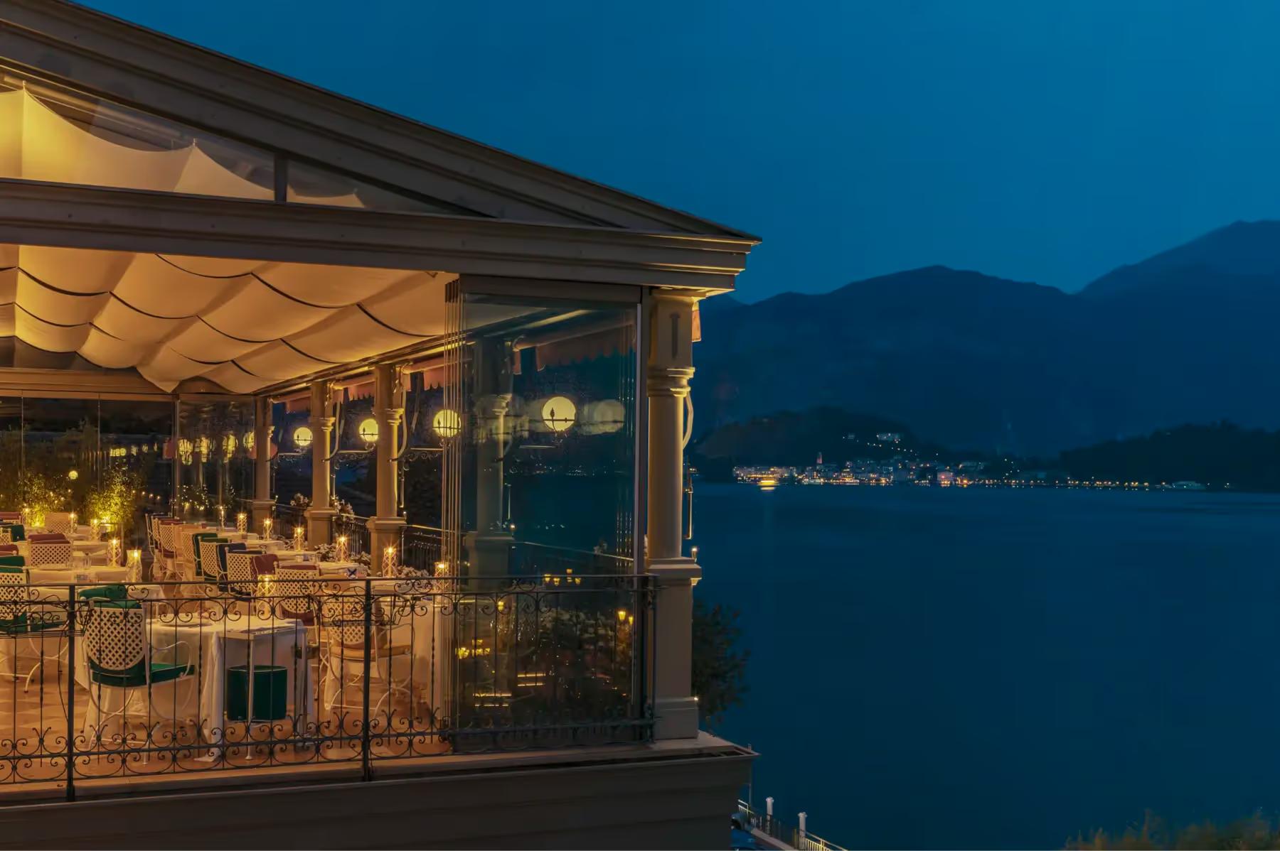 Lit restaurant pavilion reflected on dark water at twilight