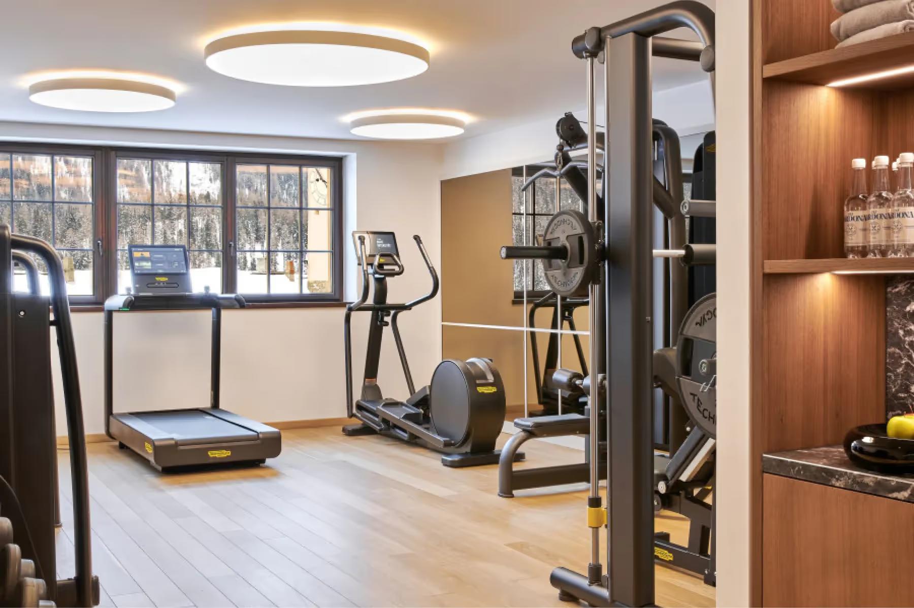 Grace La Margna St. Moritz: fitness center with treadmill, exercise equipment, and natural light from tall windows
