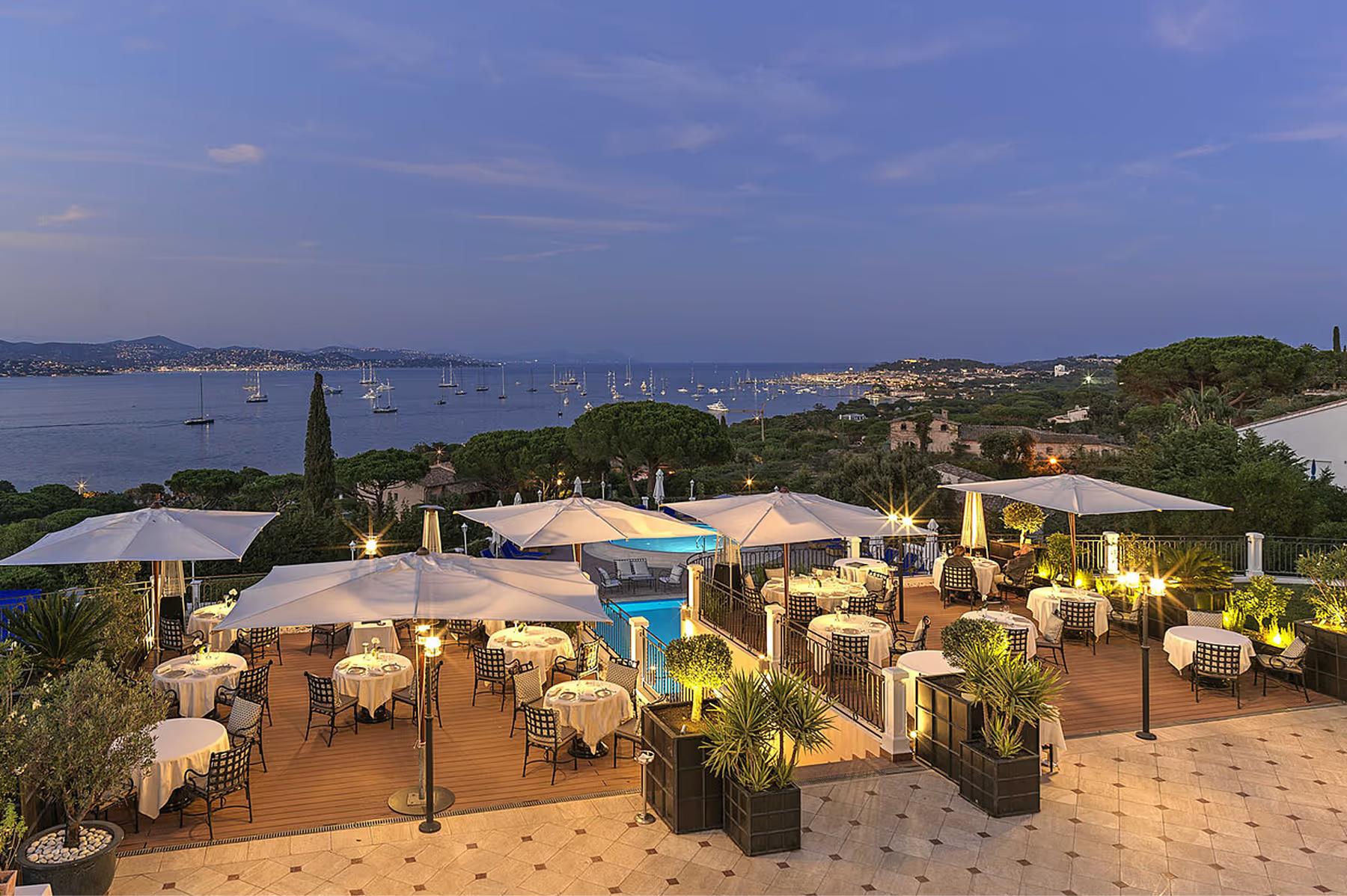 Althoff Villa Belrose: evening terrace reception with cream market umbrellas and landscaped gardens