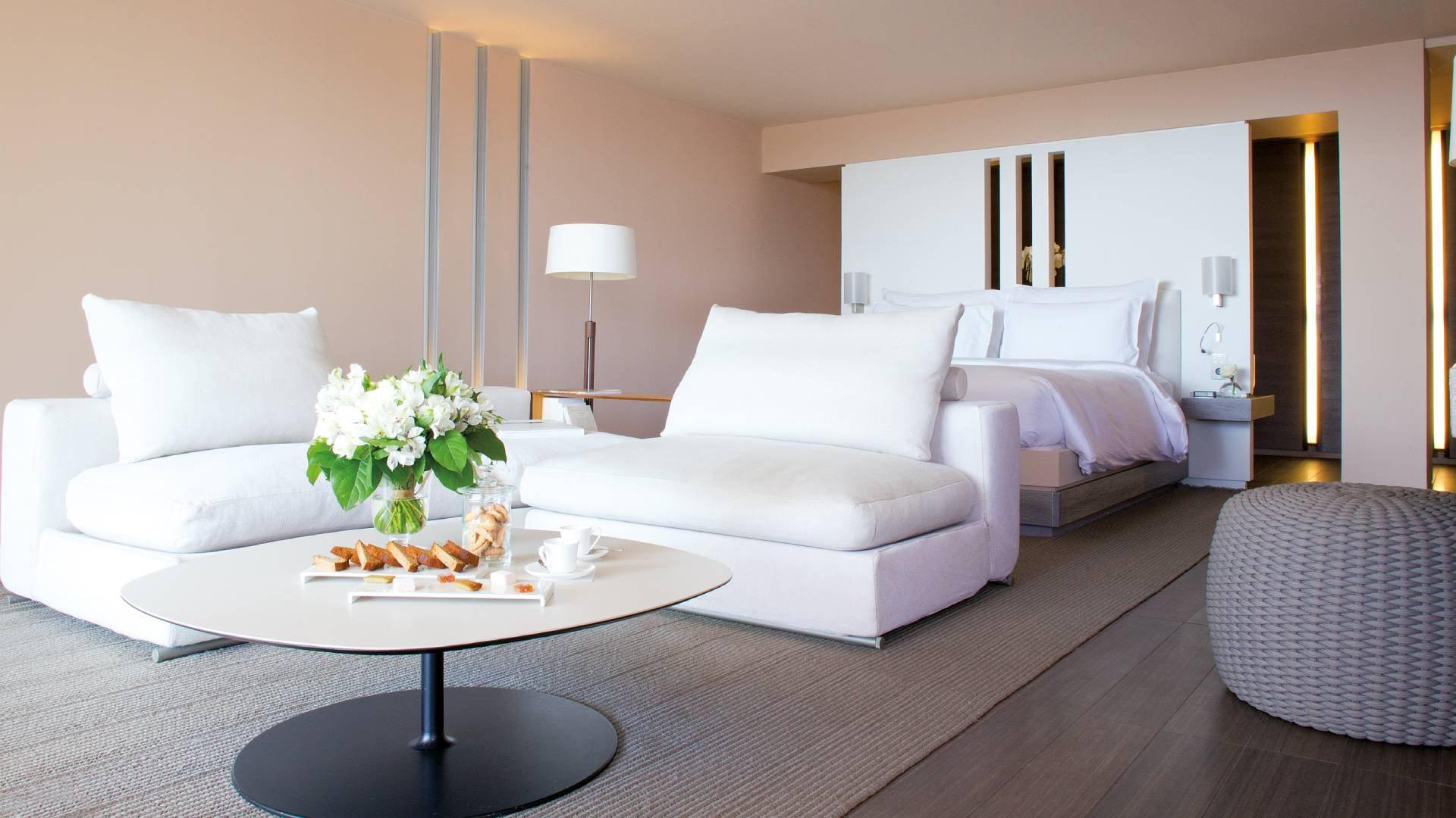 Modern suite living area with white and gray furniture and wood table
