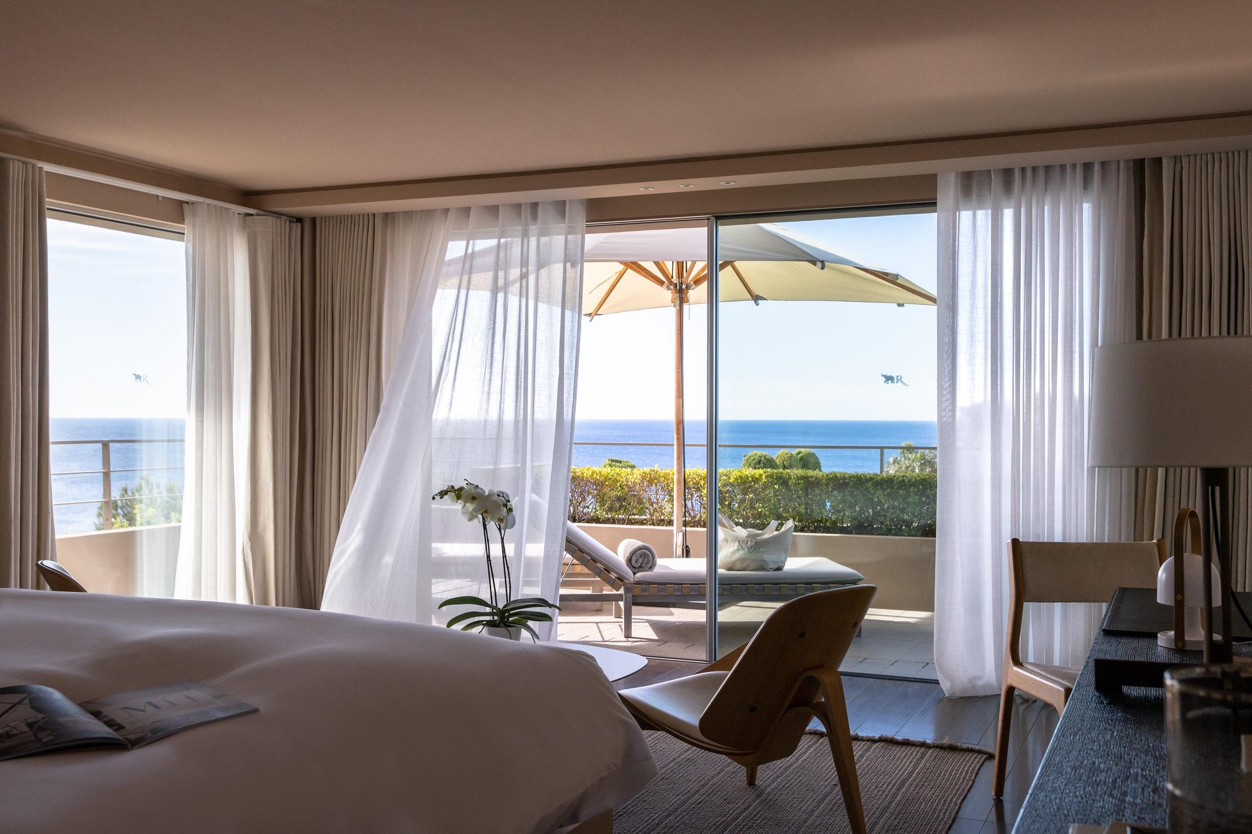 Bedroom with coastal furniture and expansive Mediterranean vista