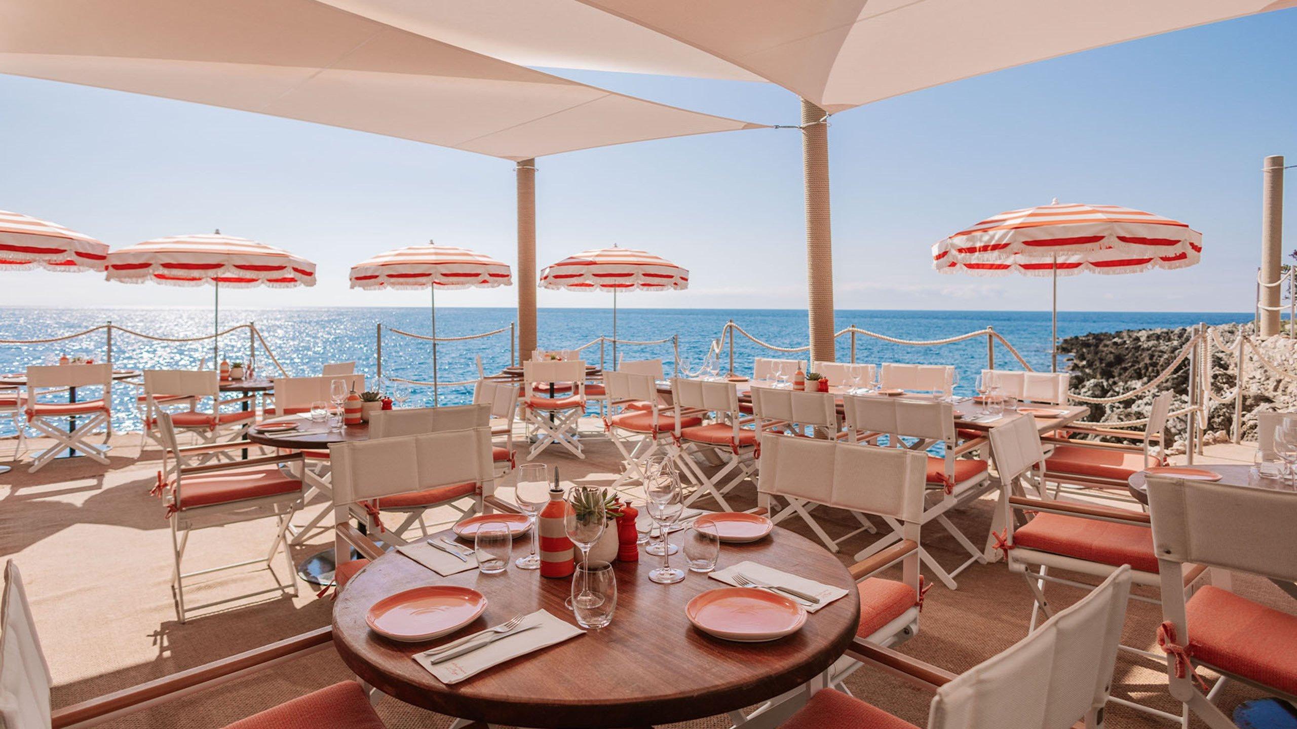 Maybourne Riviera: beachfront dining with striped umbrellas and coastal setting