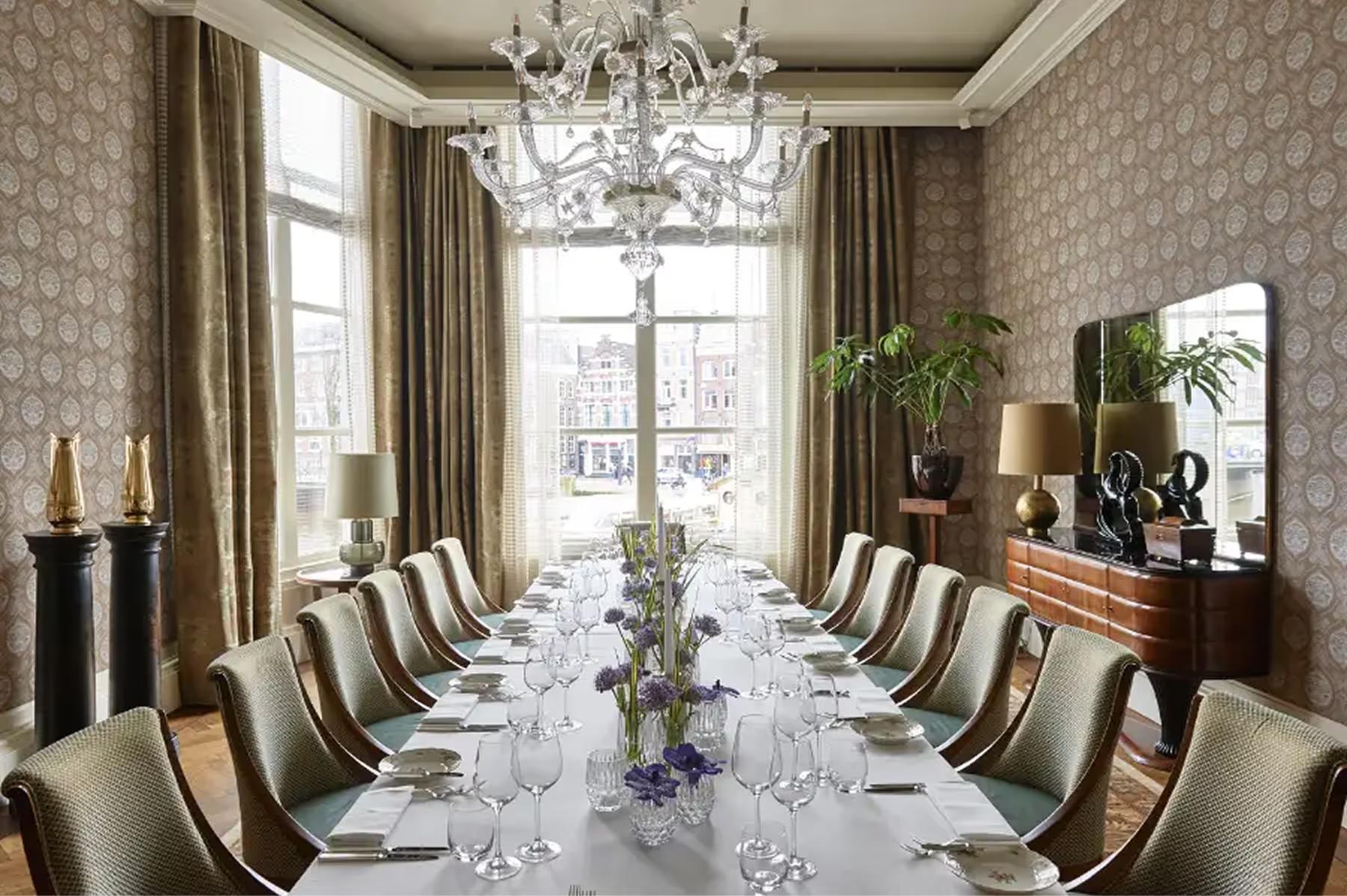 Formal dining room with long table, high ceilings, and traditional artwork on walls