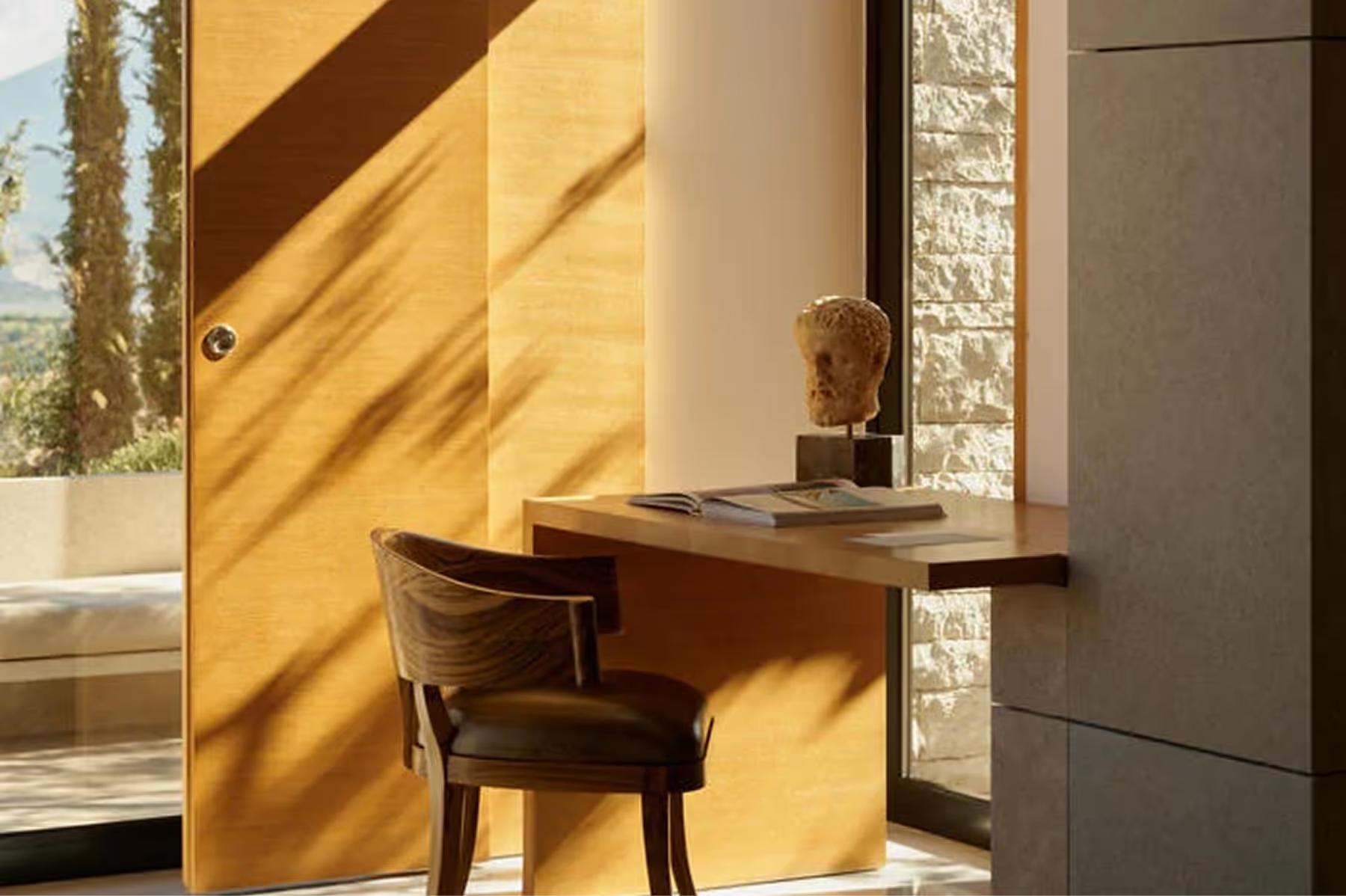 Amanzoe: writing desk in a room with dramatic golden sidelighting and sea views