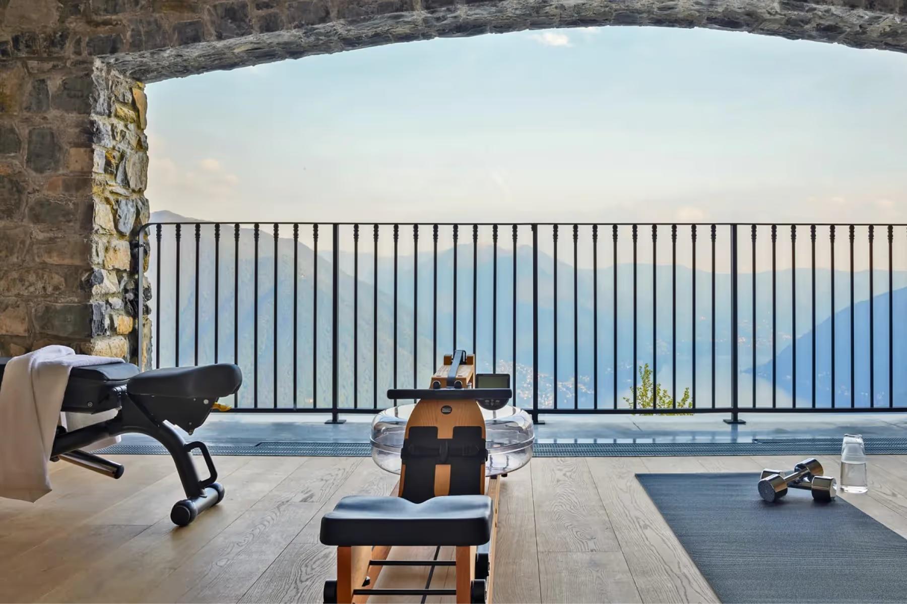 Villa Patrizia: a spa room with stone walls, lounge chairs, and mountain and lake views
