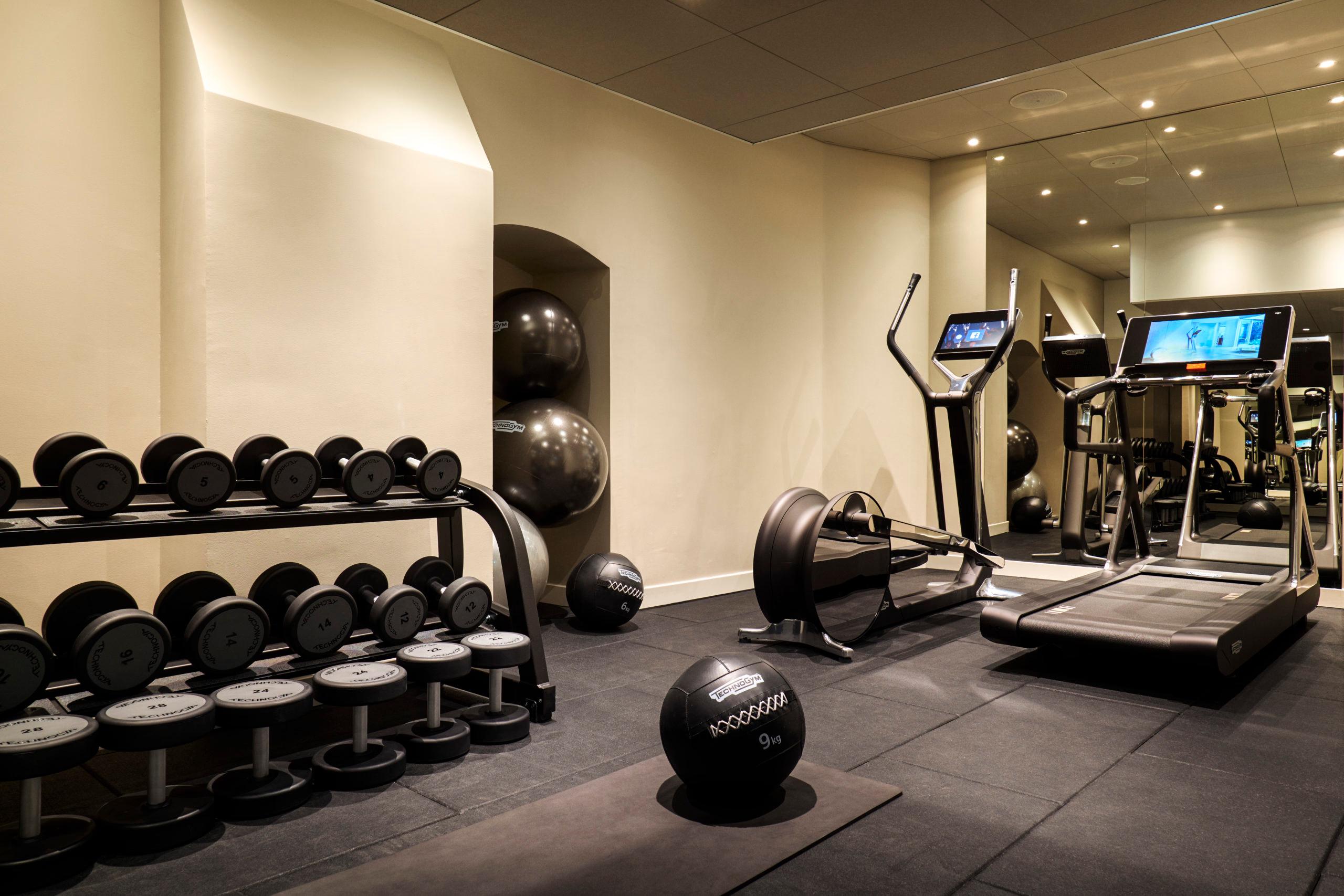Fitness center with dumbbells, cardio equipment, and exercise machines