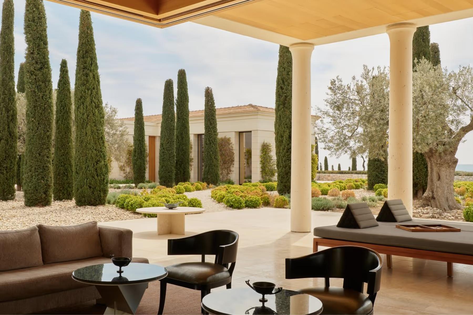 Amanzoe: infinity pool with loungers beside columned pavilion at dusk