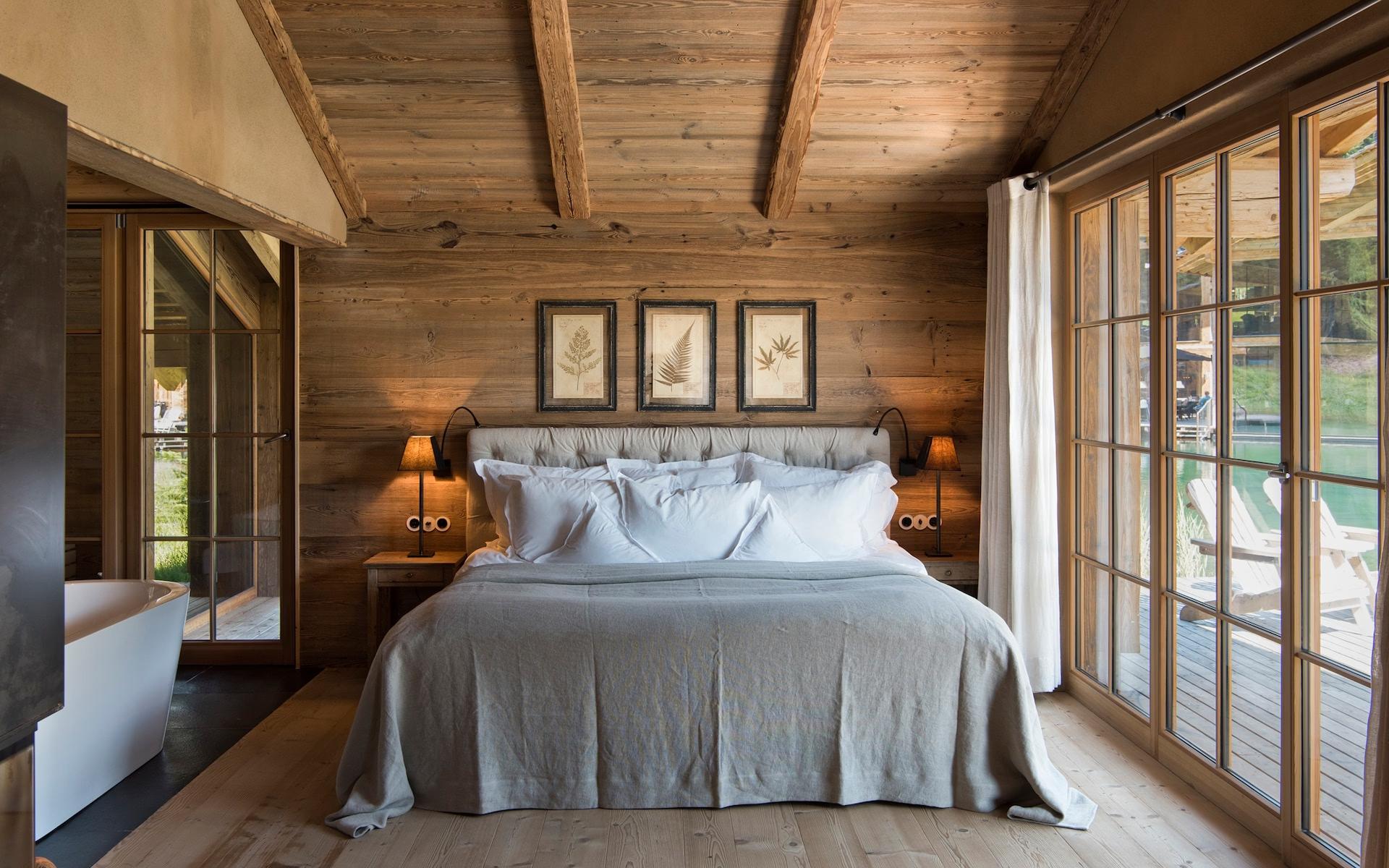 San Luis Retreat: wooden bedroom with white bedding, wooden nightstands, and glass terrace doors