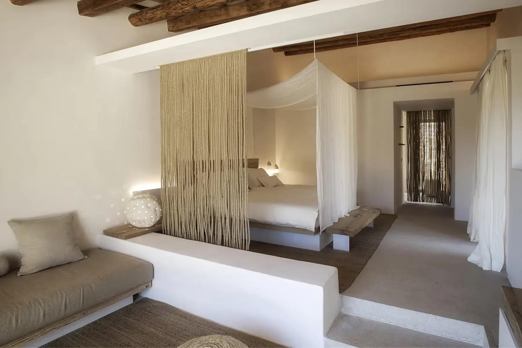 Es Racó d’Artà: bedroom with wooden partition wall separating sleeping area, beamed ceiling, and natural light