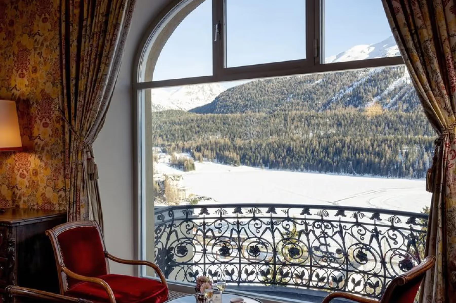 Kulm Hotel St. Moritz: a luxury bathroom in warm wood tones with marble accents and a snow-view window