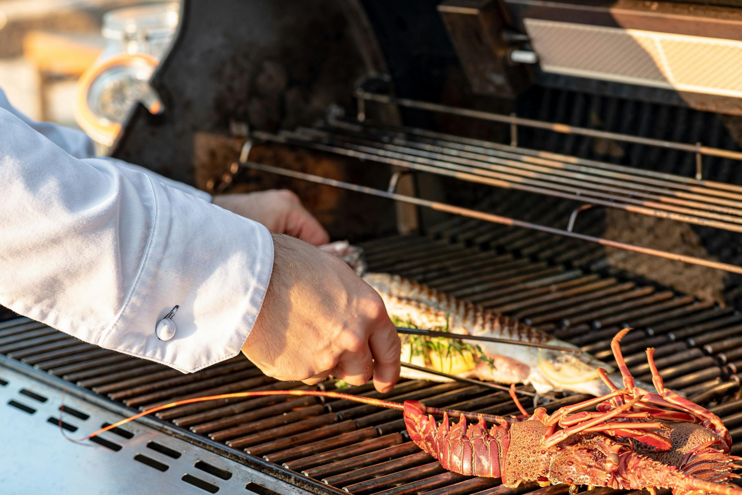 Cheval Blanc St-Tropez: chef grilling seafood over flames at outdoor station