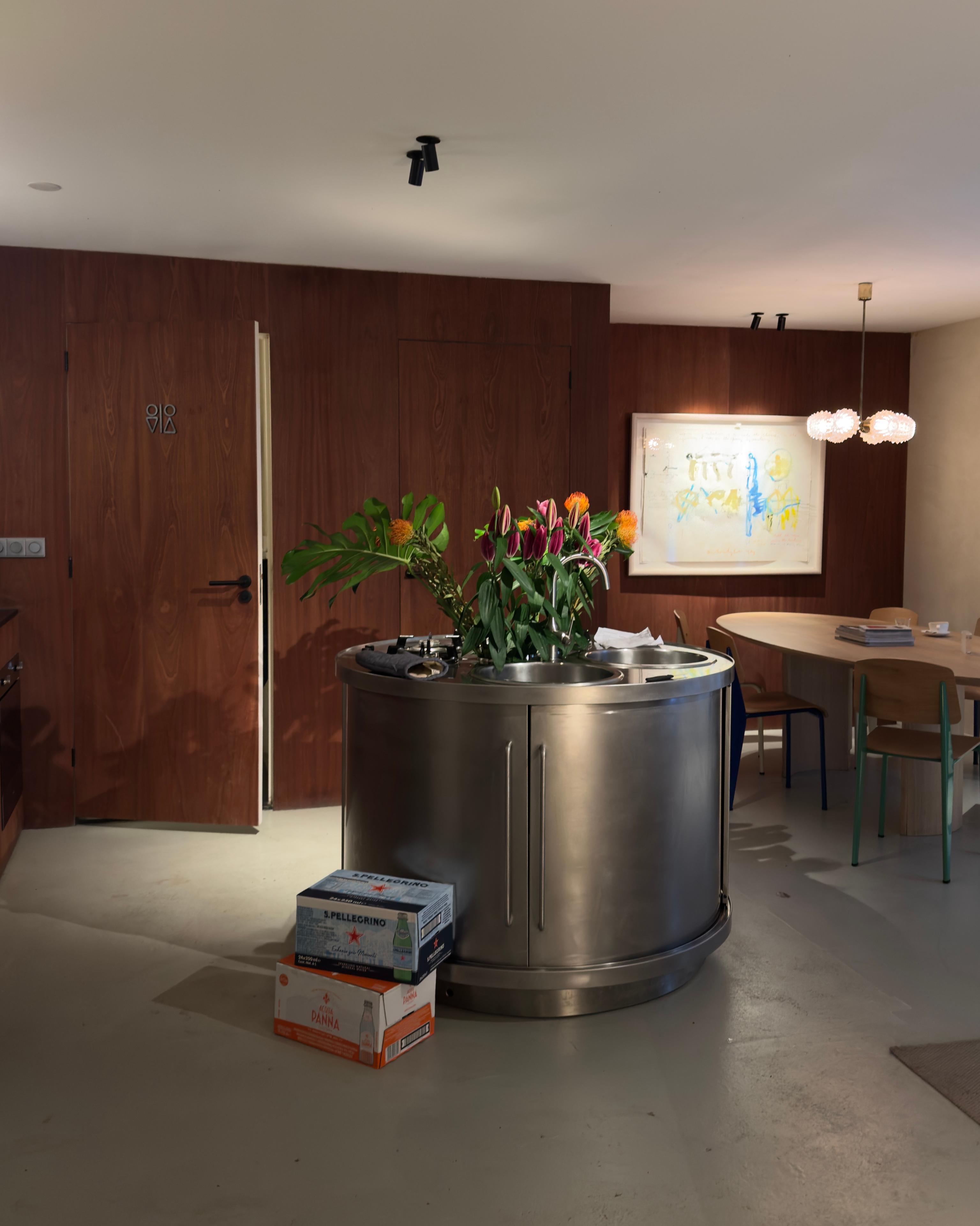 The steel kitchen island at Café Baskèts, flowers at its base