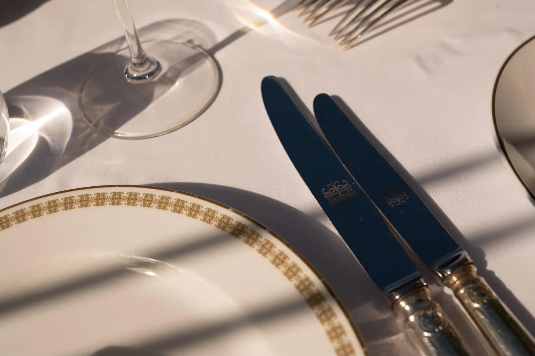 Table setting with fresh herb garnish beside wine and water glasses