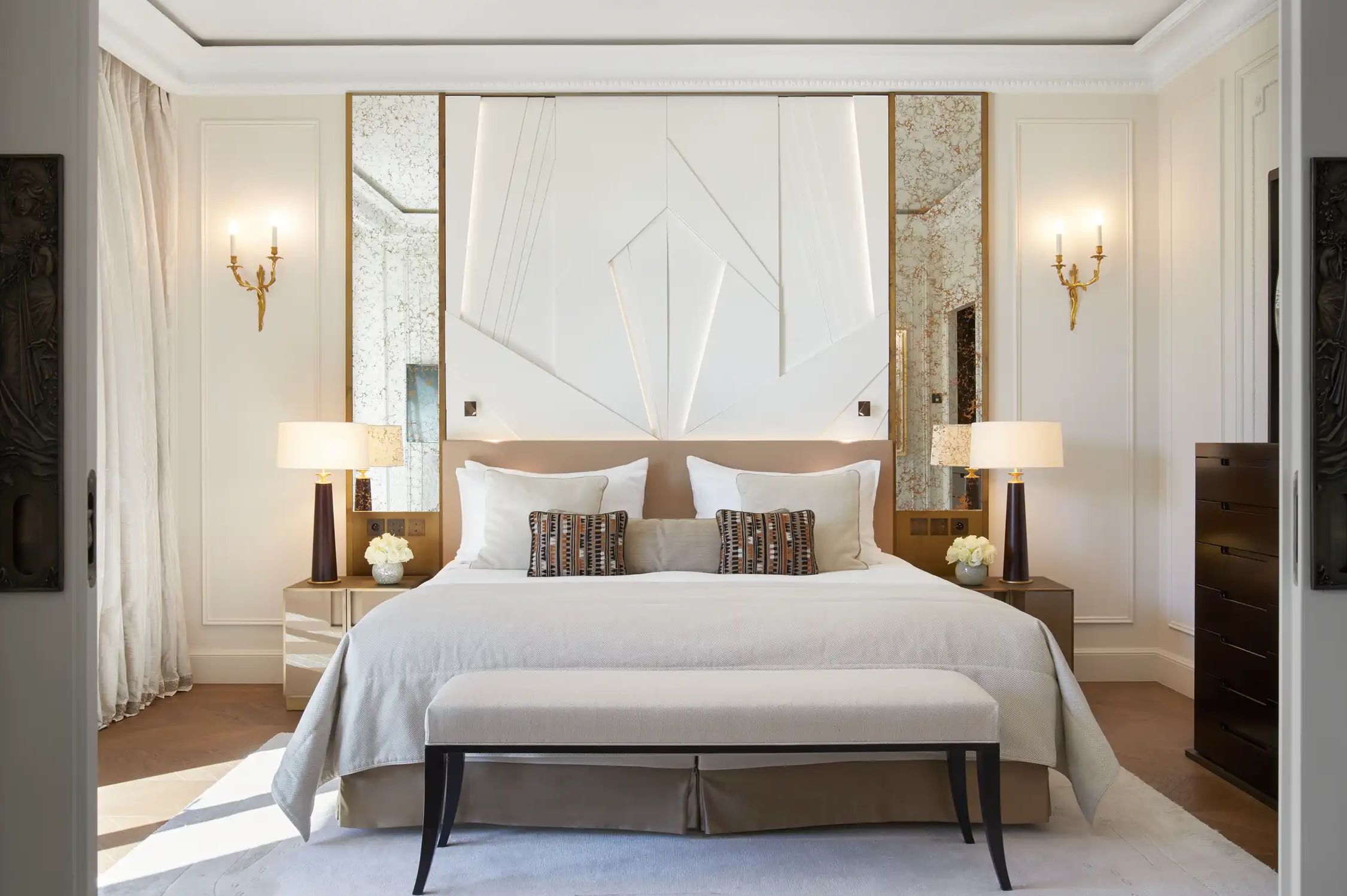 Hôtel de Paris Monte-Carlo: bedroom with white upholstered headboard, wood nightstands, gold wall sconces