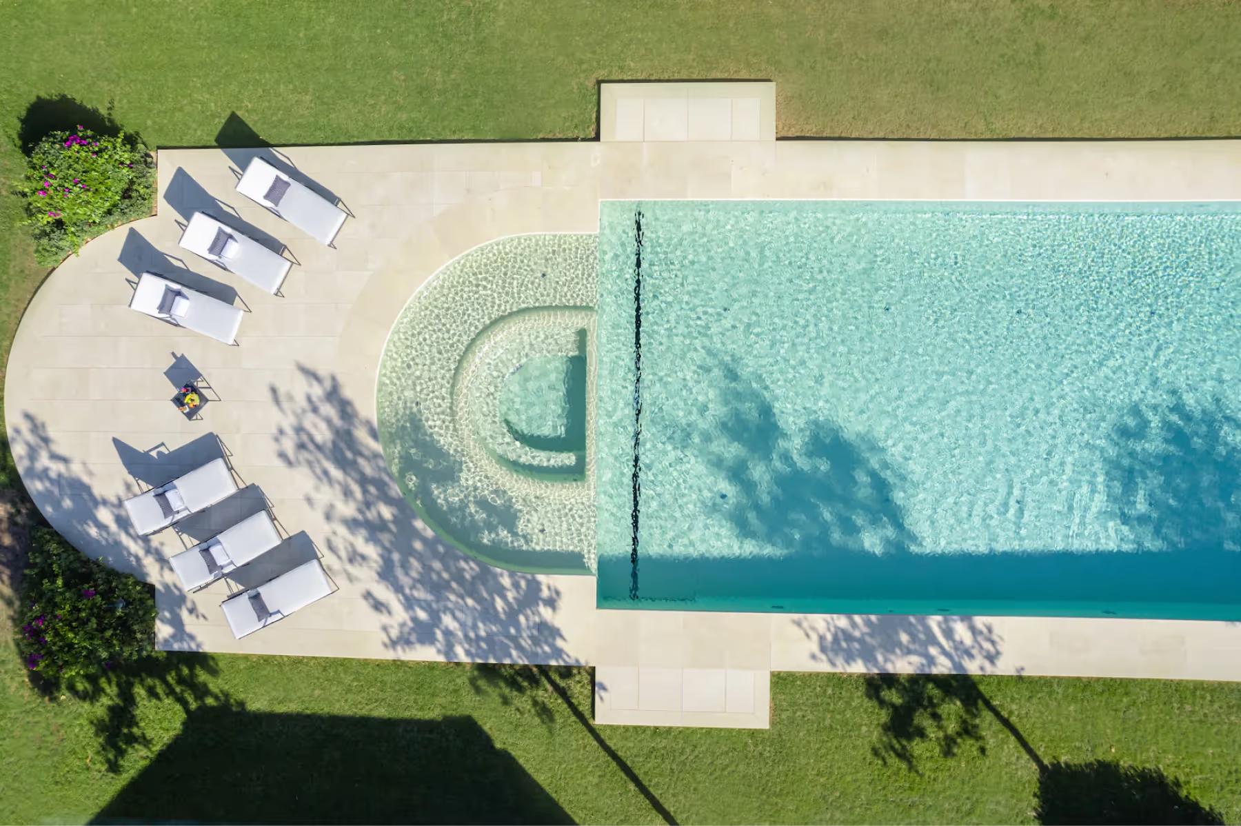 Aerial view of pool and grounds with lush landscaping and Mediterranean coastline