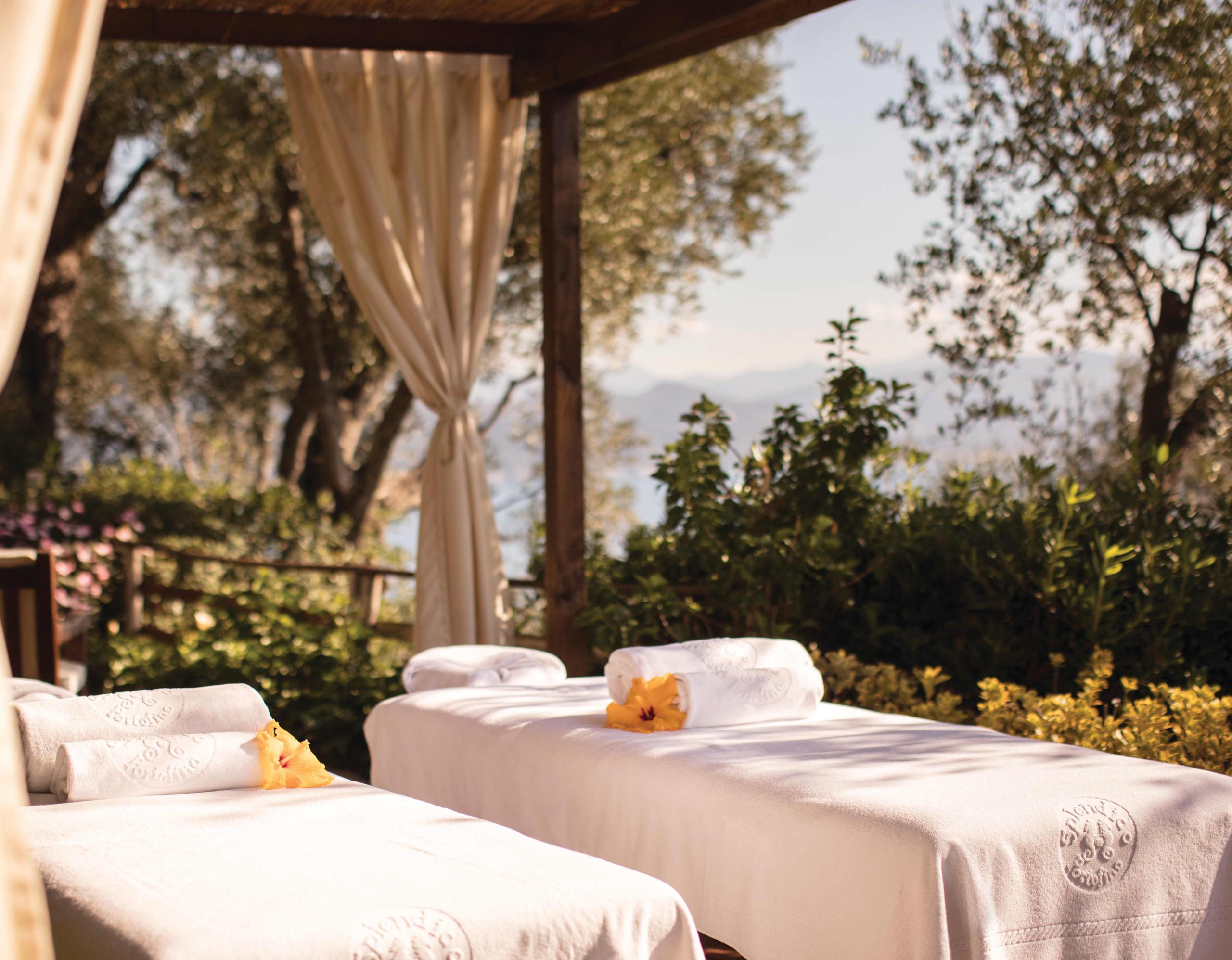 Splendido: an outdoor spa area with draped cabanas and cushioned lounging platform