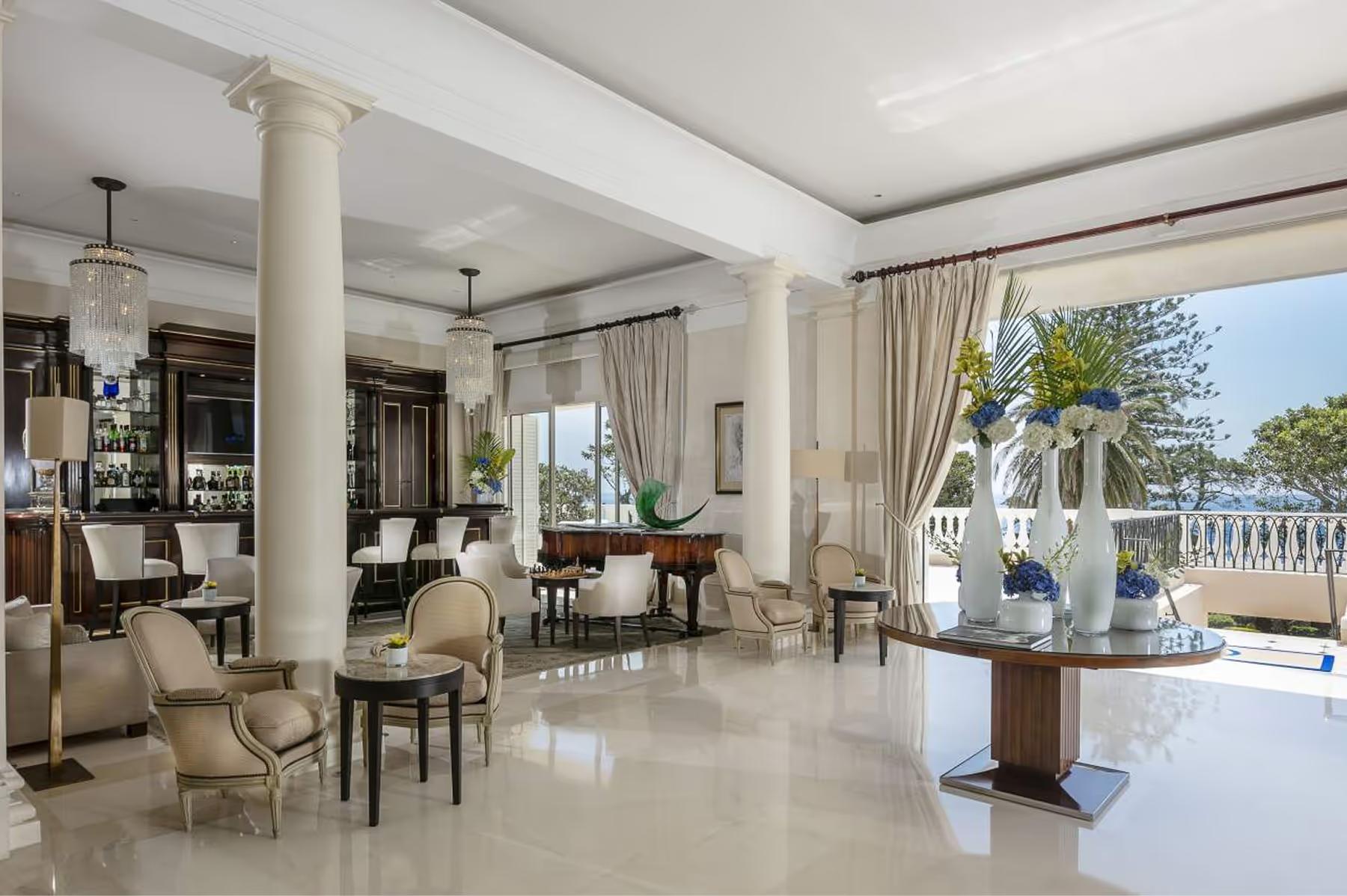 Hotel Cap-Estel: a bright lobby with columns, furniture, and panoramic sea views