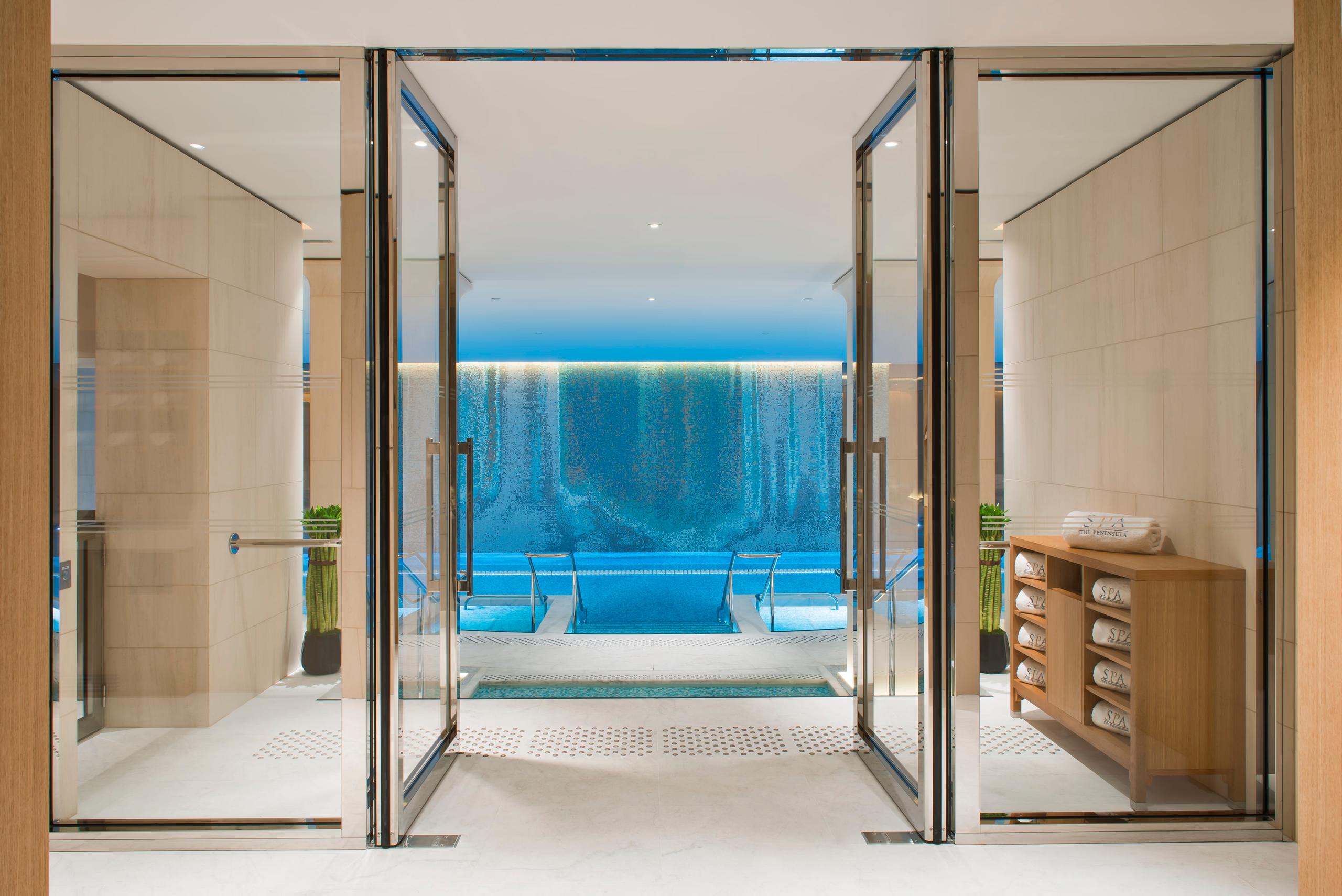 The Peninsula: indoor swimming pool with curved ceiling, blue water, and overhead lighting in a spa setting