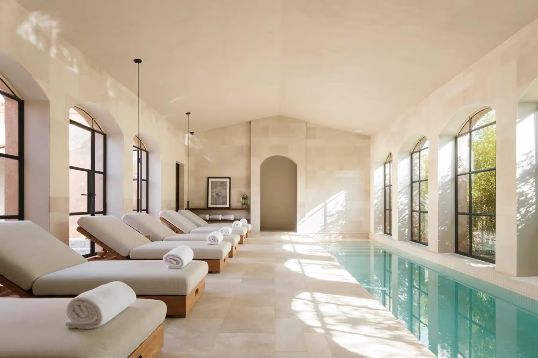 Can Ferrereta: indoor pool with loungers and bright natural light from large windows