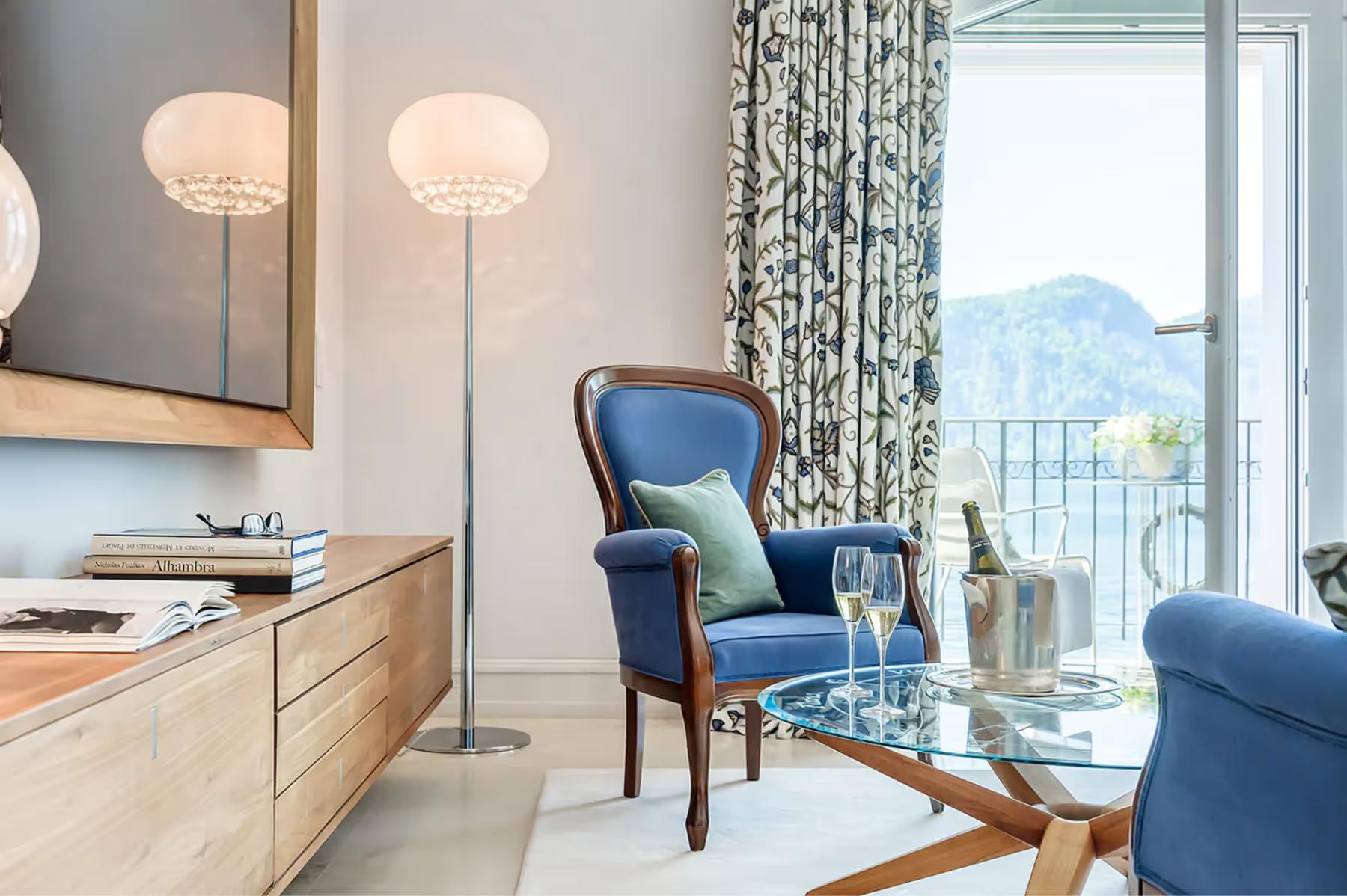 Park Hotel Vitznau: suite sitting area with blue accent chair and panoramic mountain views