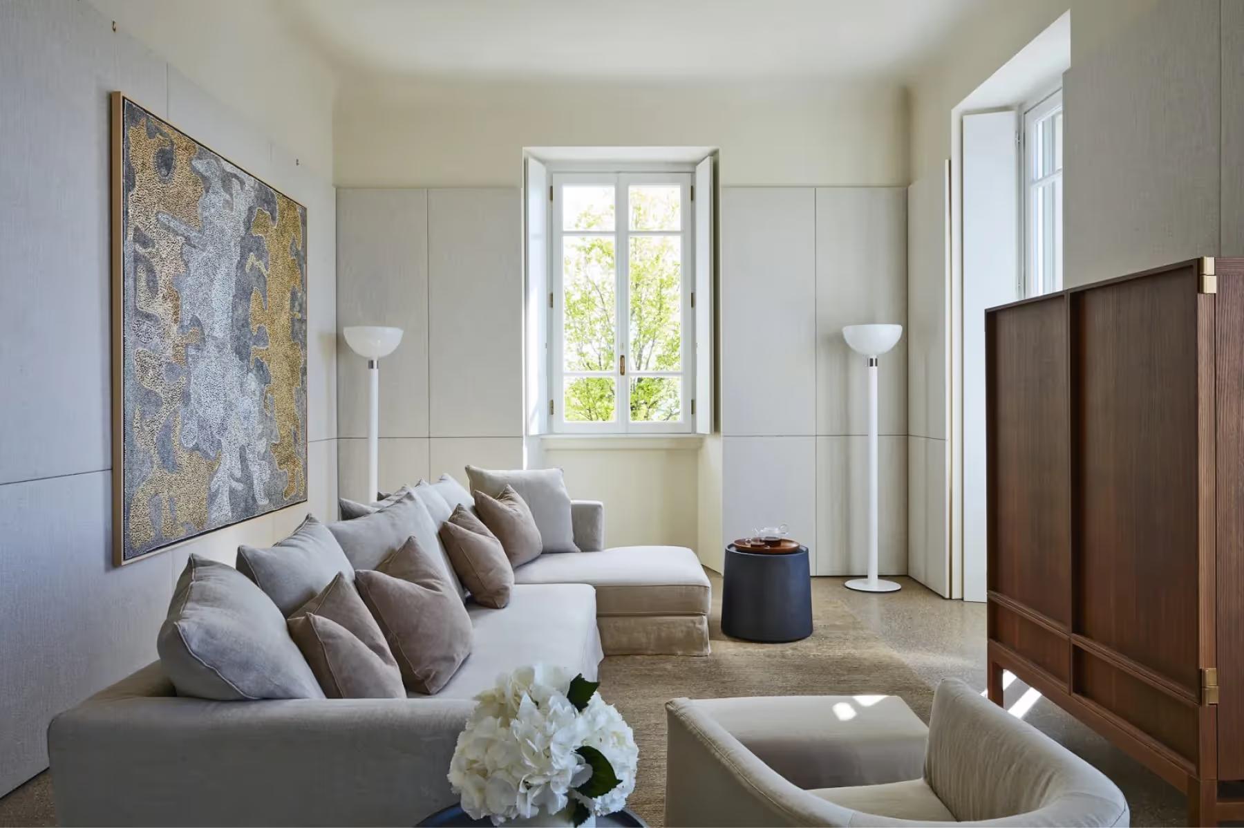 Villa Patrizia: a living room with cream sofa, artwork, tall windows, and neutral tones