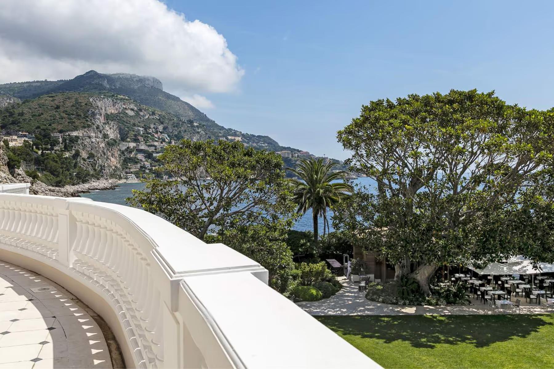 Hotel Cap-Estel: curved white railing against a hillside and Mediterranean shoreline