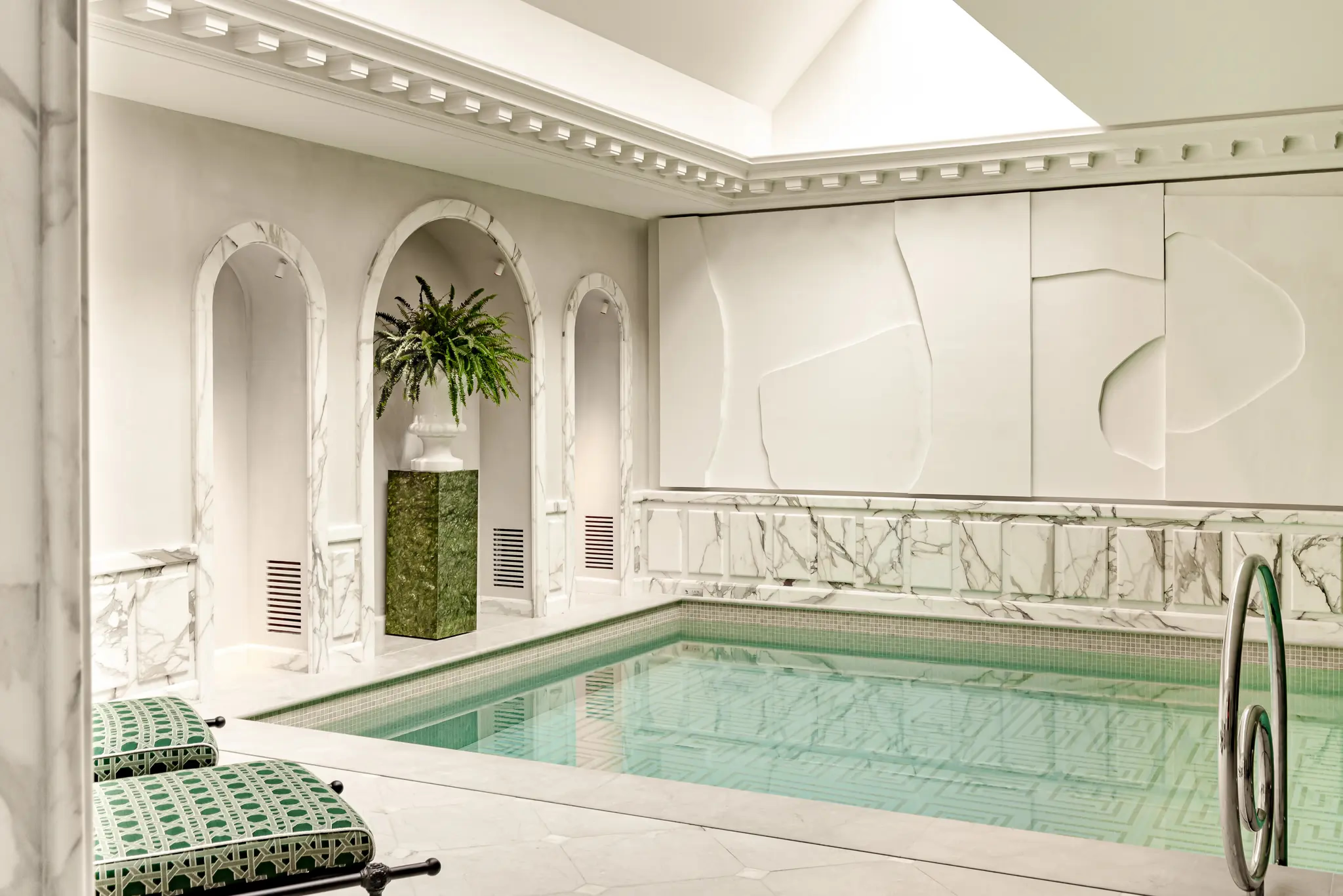 Saint James: indoor spa pool with blue water, arched alcoves, and marble cabinetry