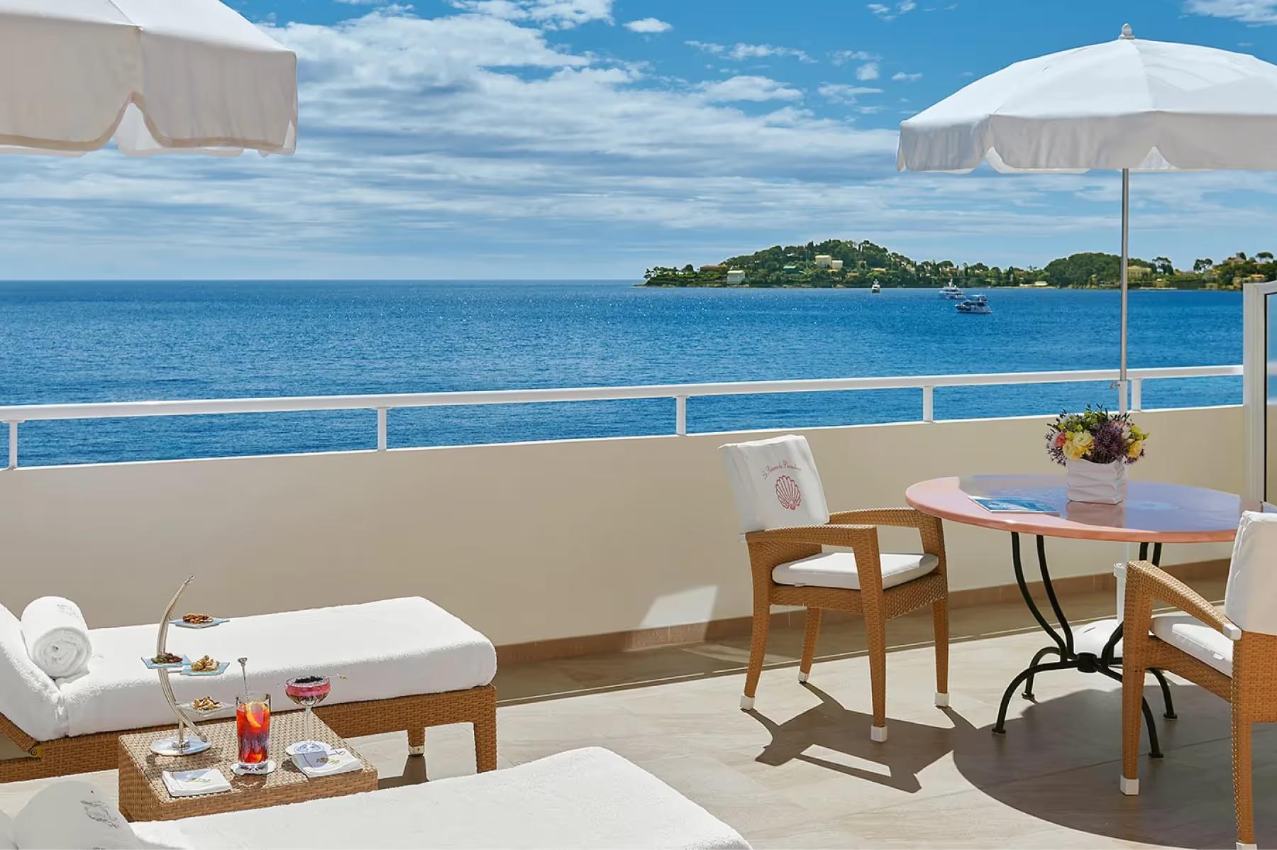 Balcony lounge with white sun loungers and Mediterranean vista