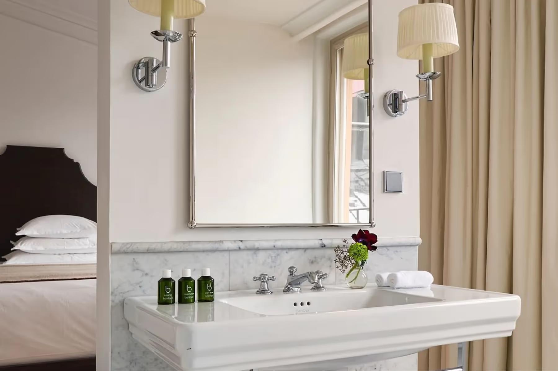 Villa Dagmar: marble bathroom sink with mirror, brass fixtures, and spa-quality amenities