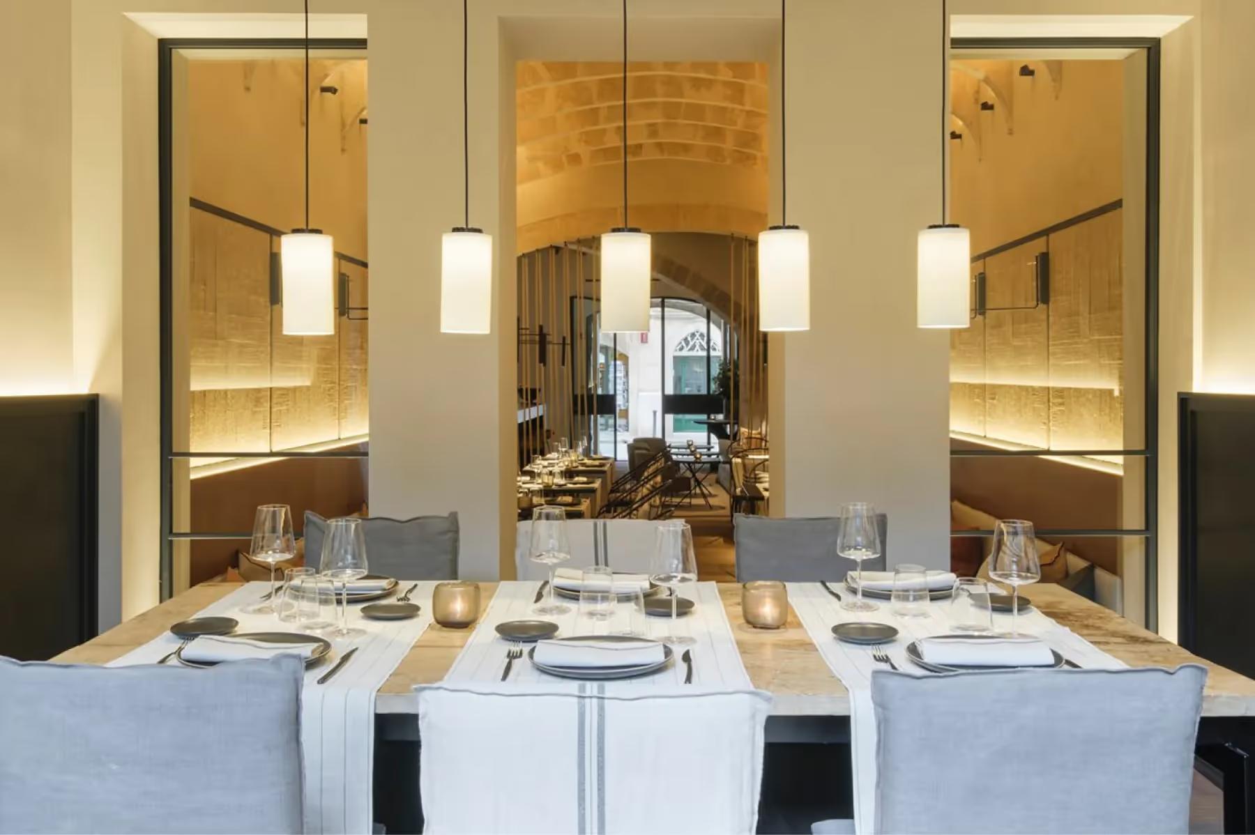 Can Ferrereta: fine dining room with arched windows and formally set table